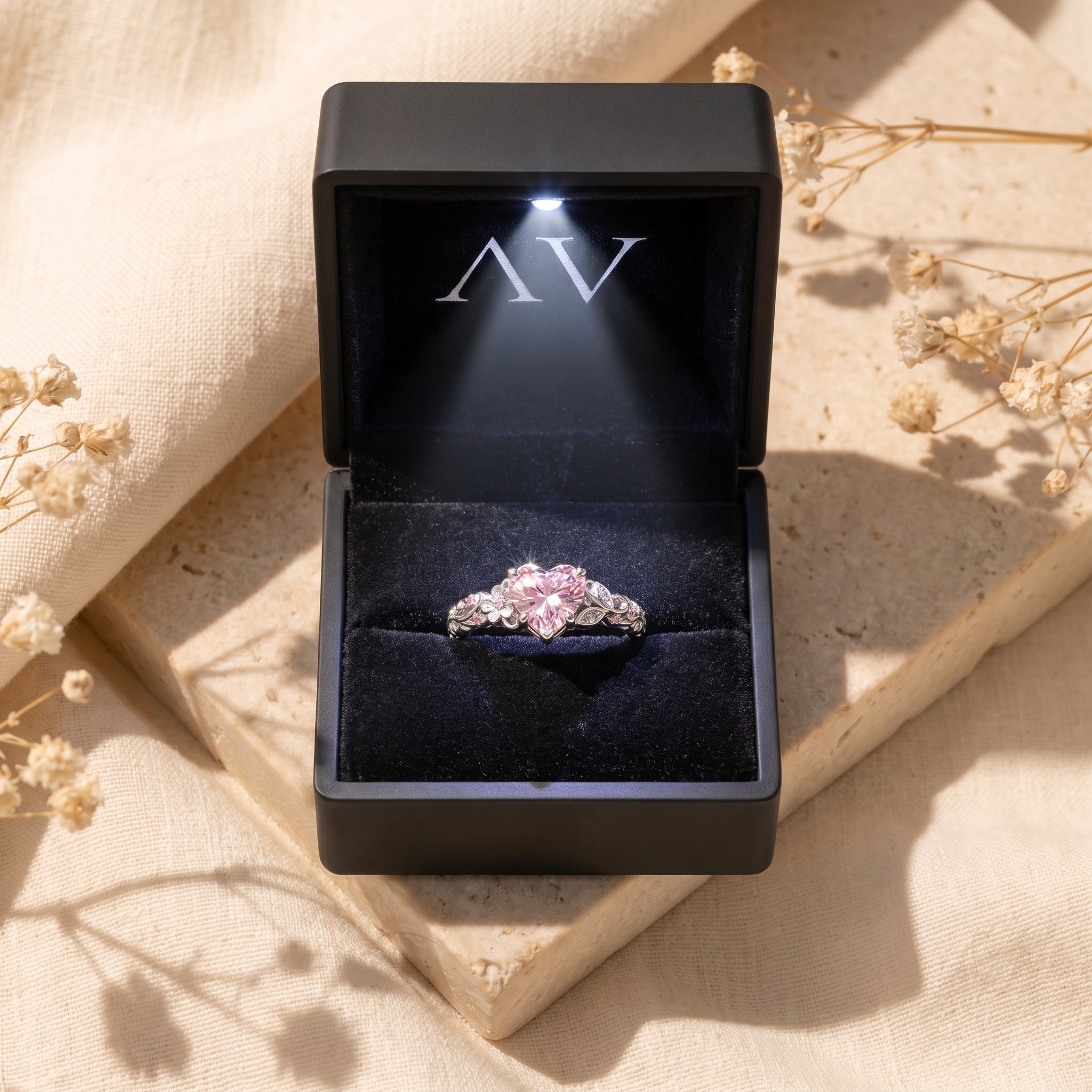 Silver heart-cut pink diamond ring in a lighted gift box.
