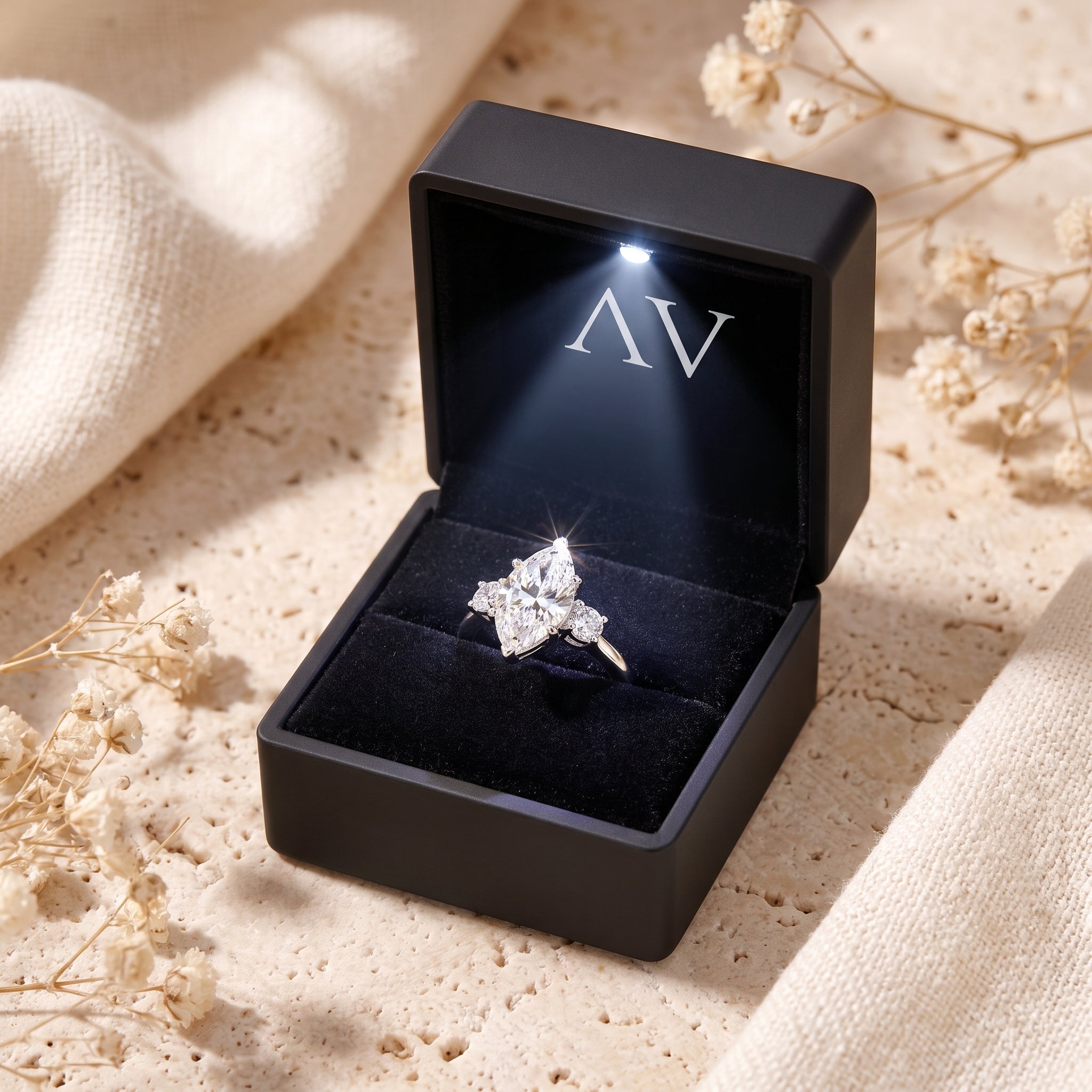 Marquise simulated diamond silver ring in a lighted black gift box.