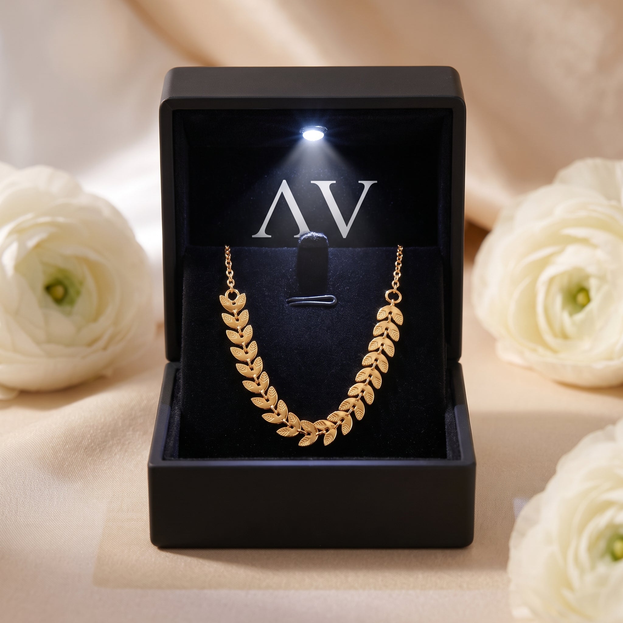Gold leaf necklace in a black lighted jewelry gift box.