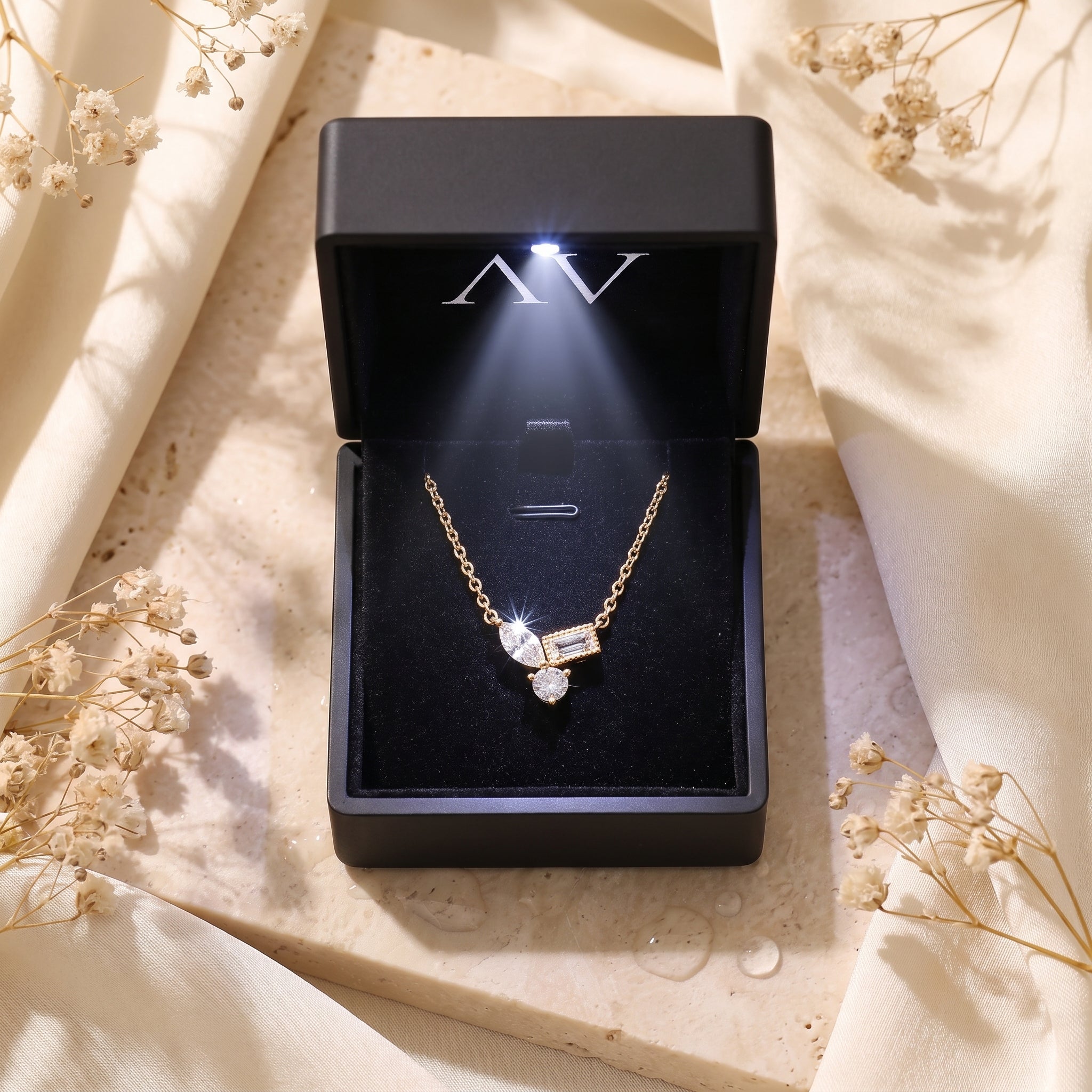 18K gold Elyssara necklace presented in a black LED-lit jewelry gift box.