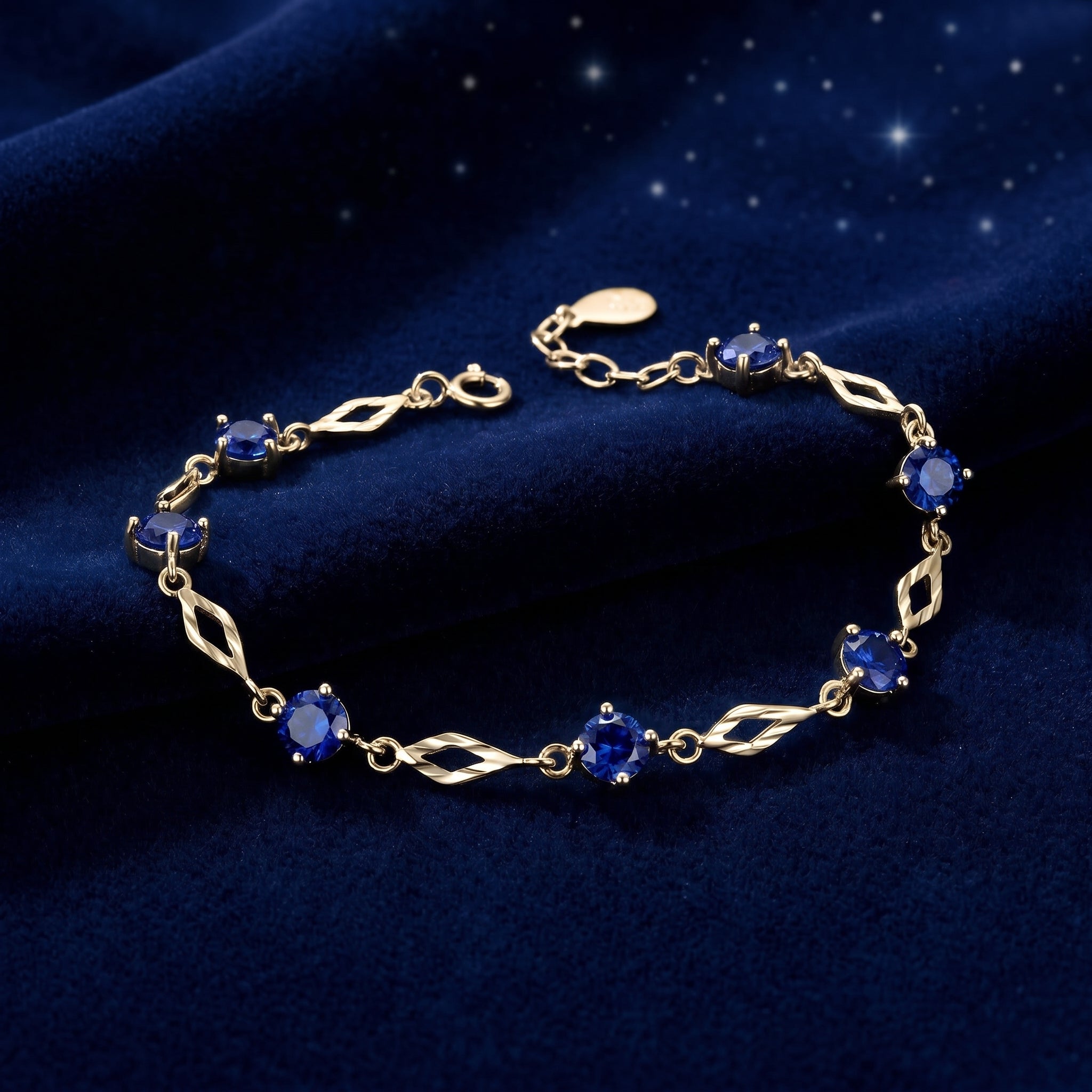 Solid yellow gold station bracelet featuring simulated sapphires.