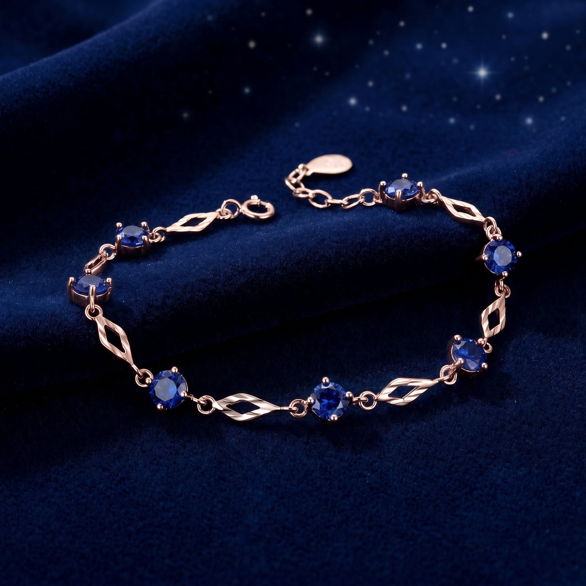 Solid rose gold station bracelet featuring simulated sapphires.