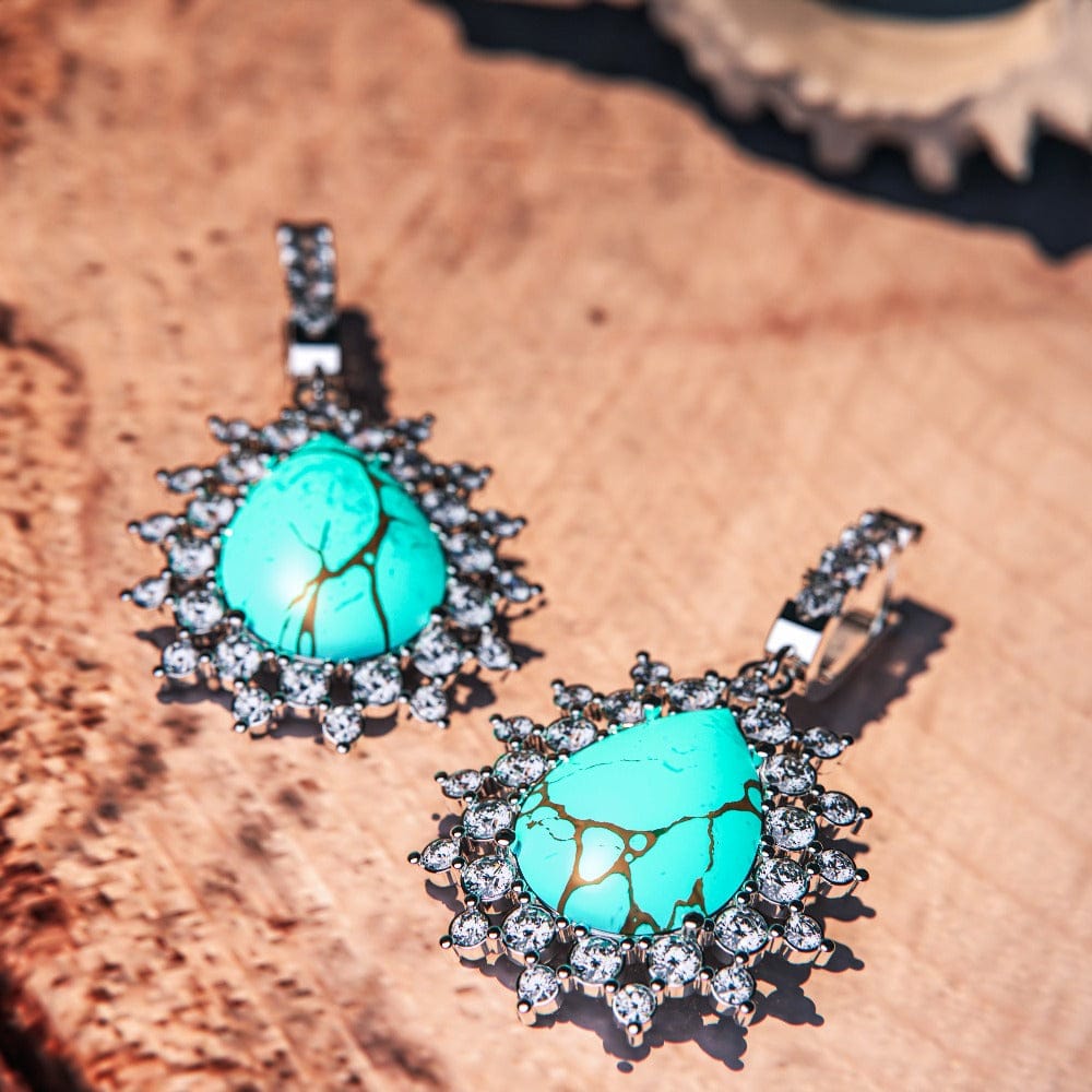 Blue Lagoon Turquoise Earrings featuring turquoise stones set in S925 sterling silver laying on flat surface in close up high detail view