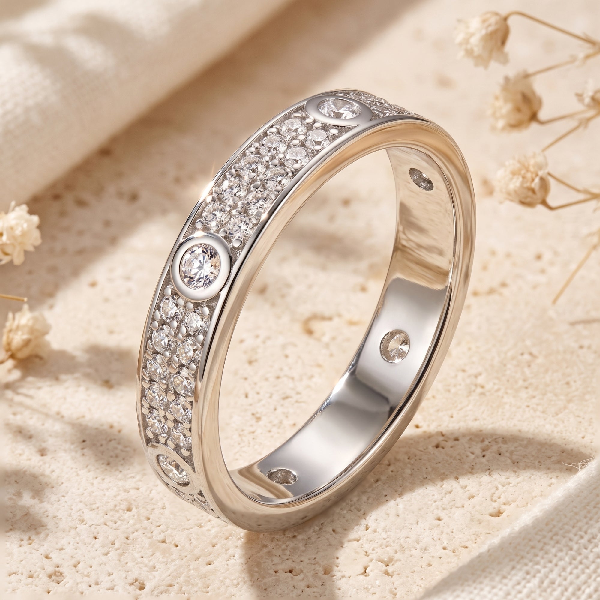 S925 sterling silver pavé CZ ring angled on a stone surface with dried flowers.
