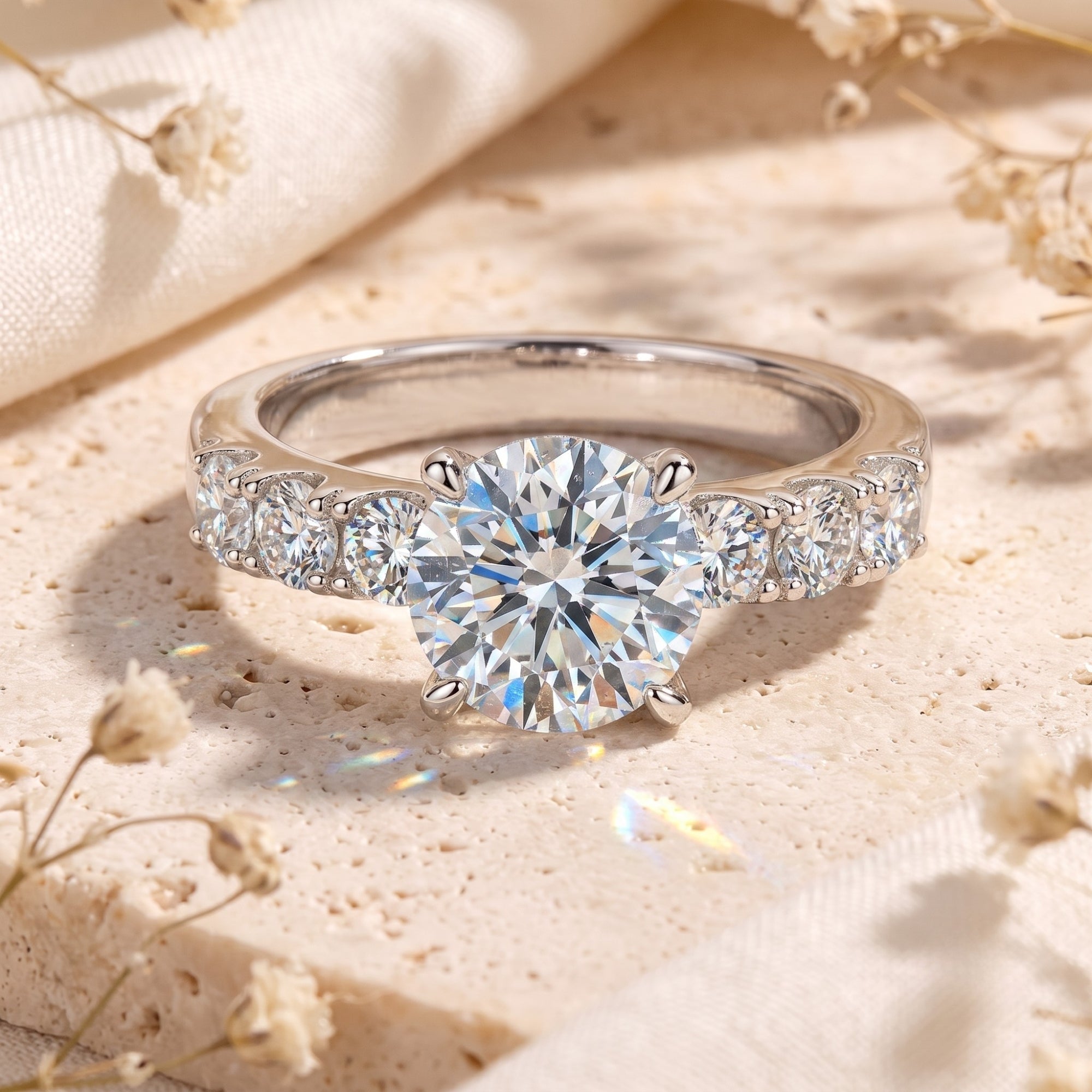 Round cut simulated diamond ring in S925 sterling silver on a stone surface with floral accents.