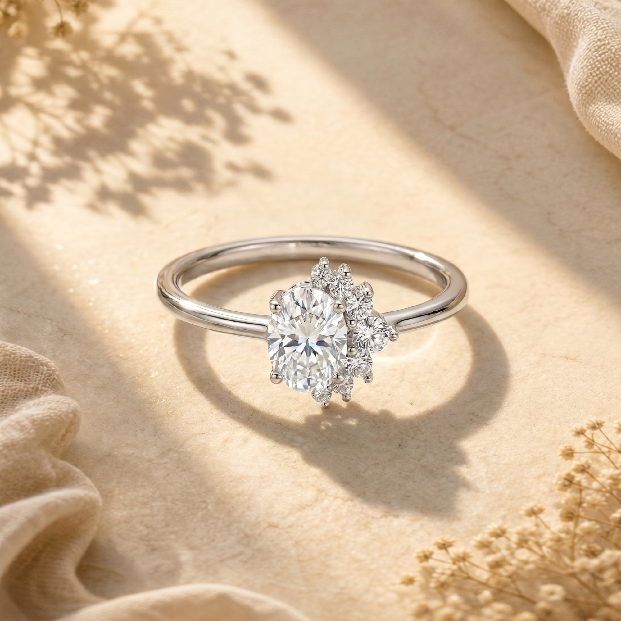 Sterling silver promise ring with 2CT oval moissanite and asymmetric cluster on a neutral lifestyle background.