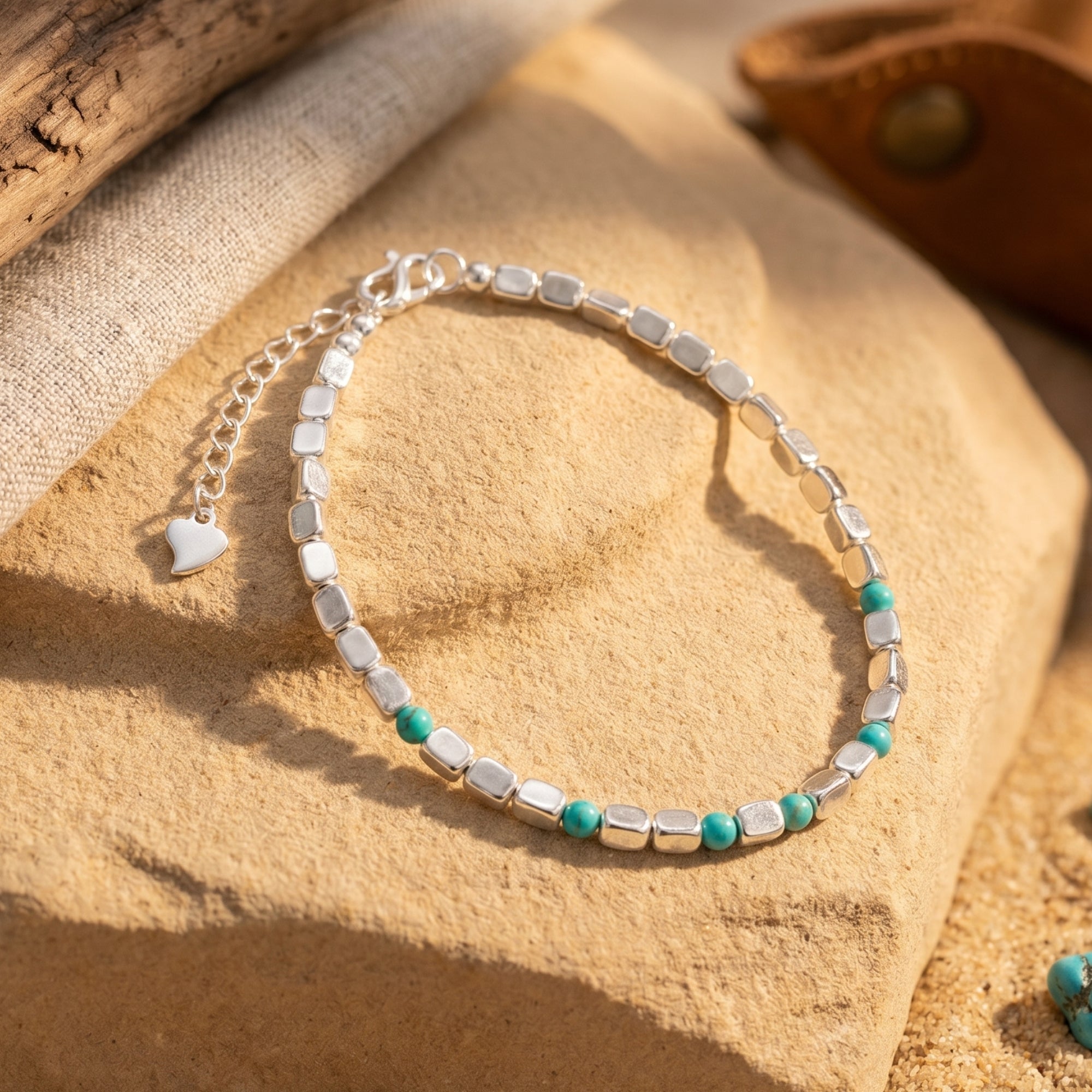 Silver bead bracelet with turquoise accents on a desert rock.