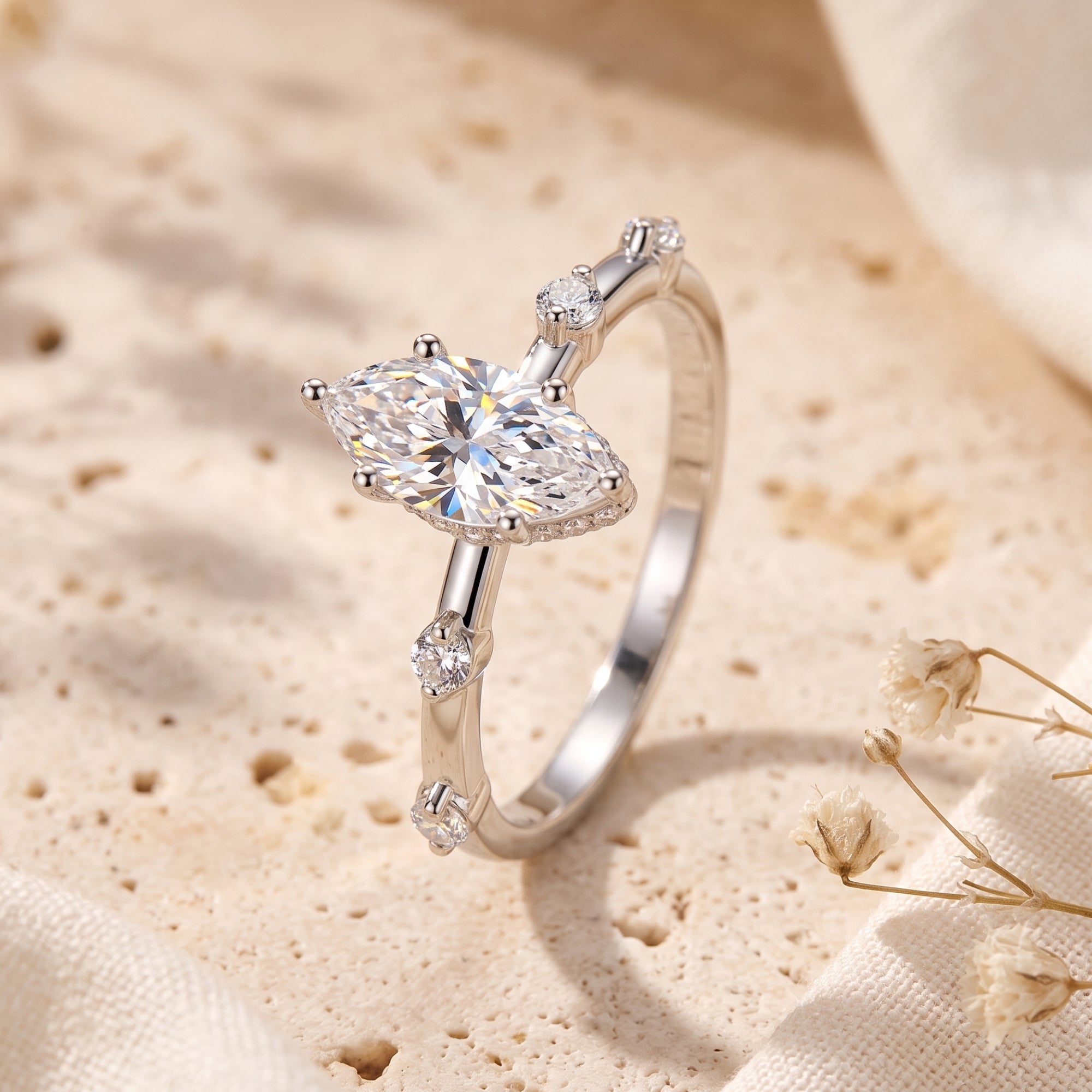 Side view of the Isabetta marquise cut simulated diamond ring in sterling silver on a textured stone surface.