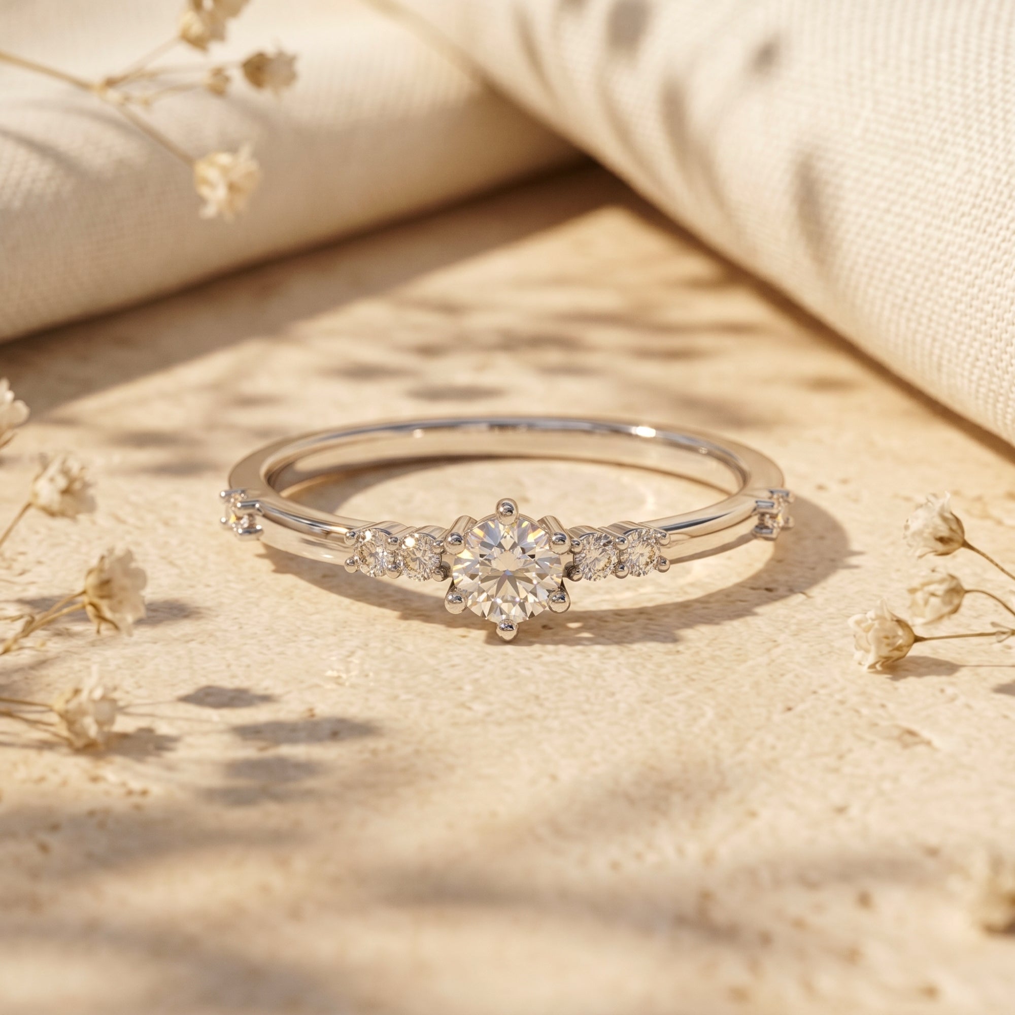 Round cut moissanite engagement ring in S925 sterling silver on a neutral lifestyle background with dried flowers.
