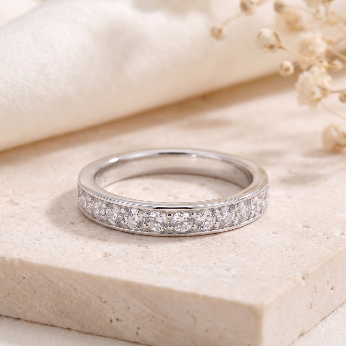 S925 silver eternity ring with round cubic zirconia in channel setting on stone.