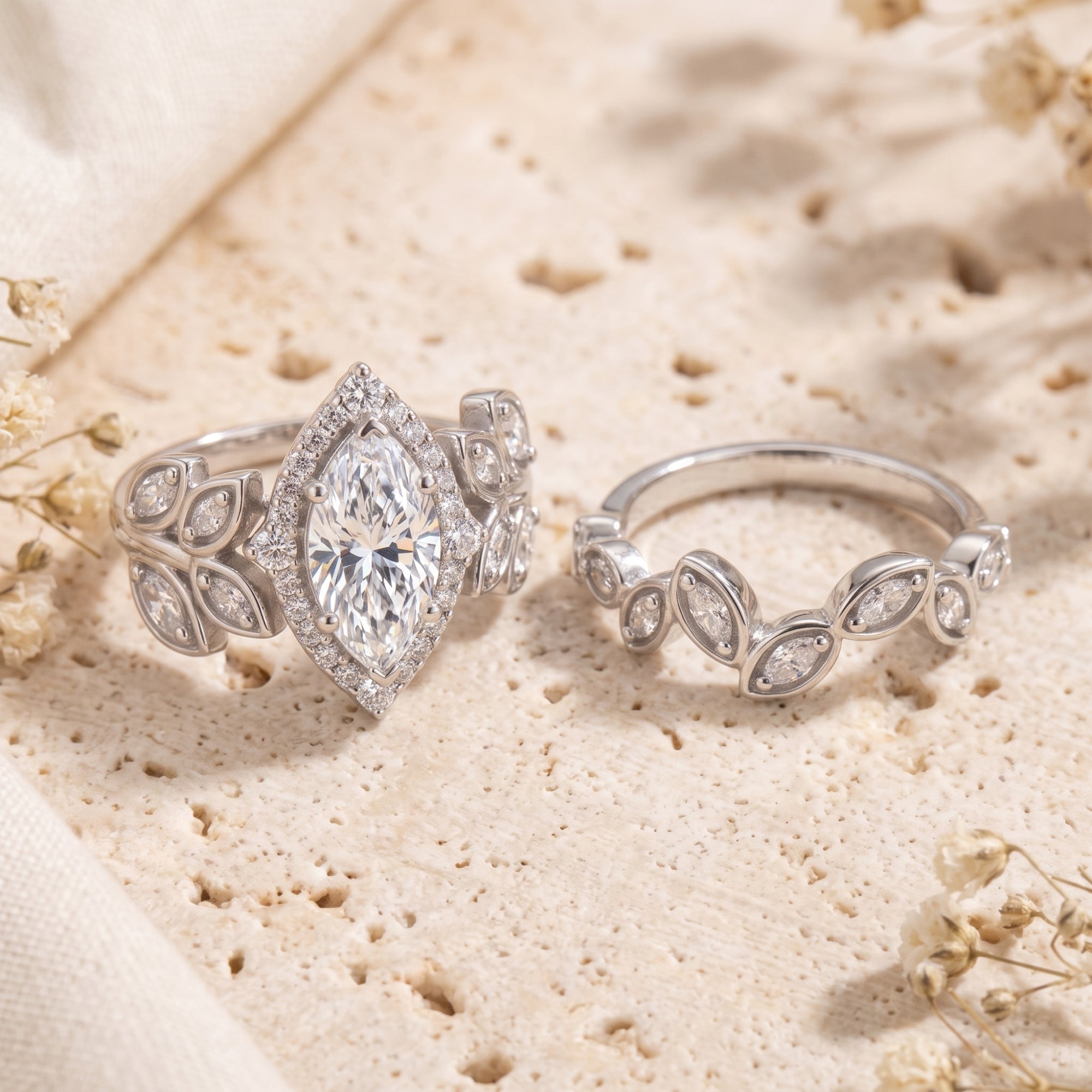 Sterling silver marquise simulated diamond promise ring with leaf motifs on a textured stone background.