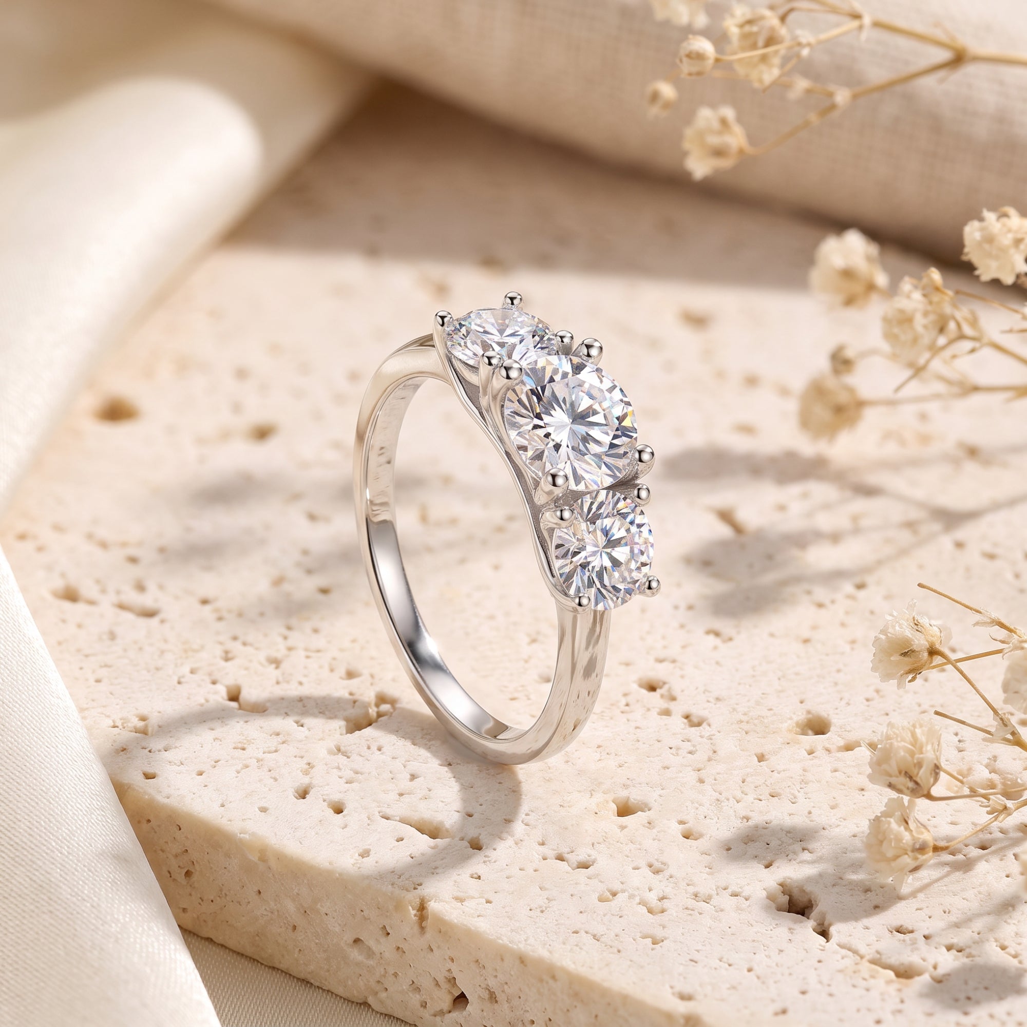 Three-stone silver promise ring with round simulated diamonds on stone.