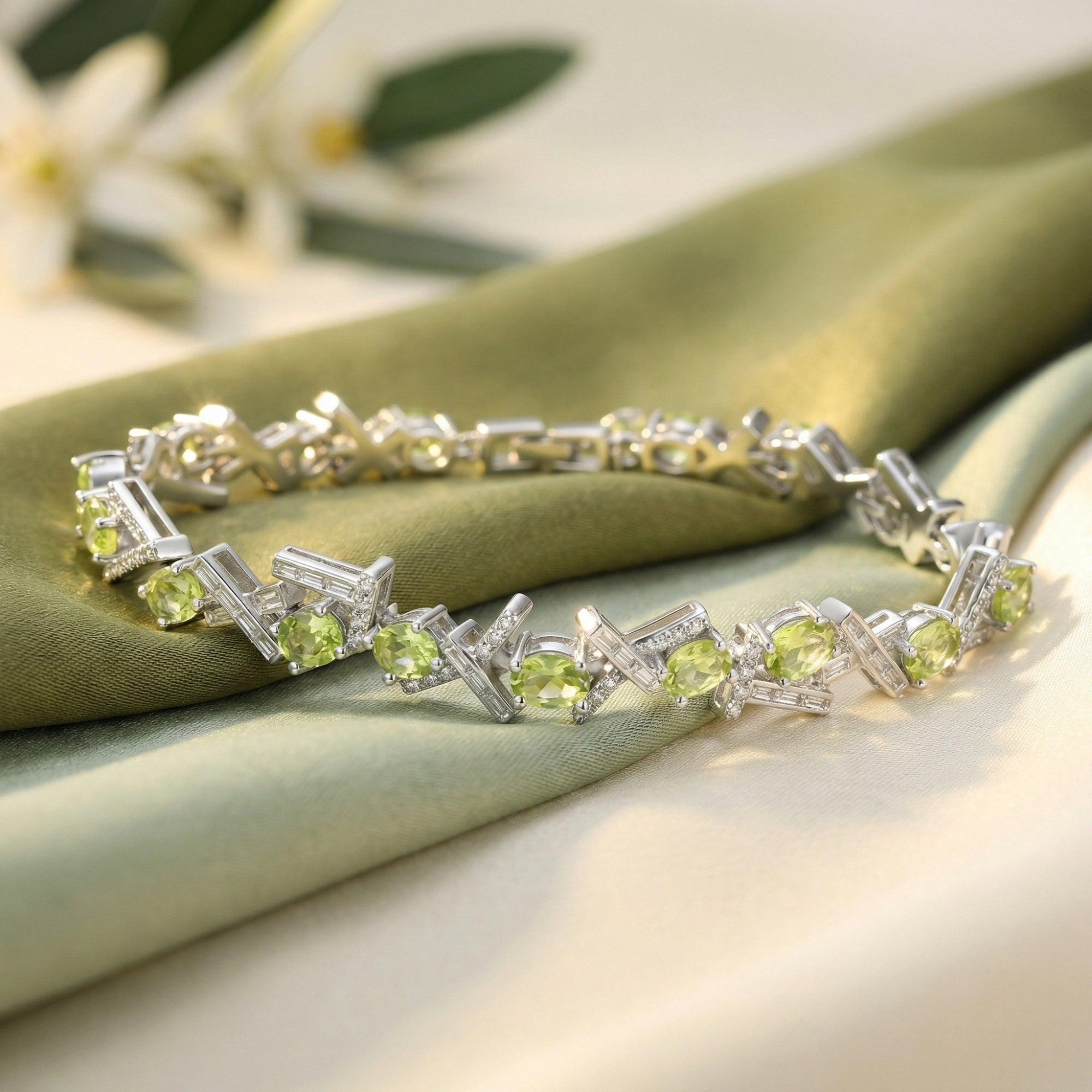 Oval cut green peridot bracelet in S925 sterling silver displayed on green silk fabric with floral accents.