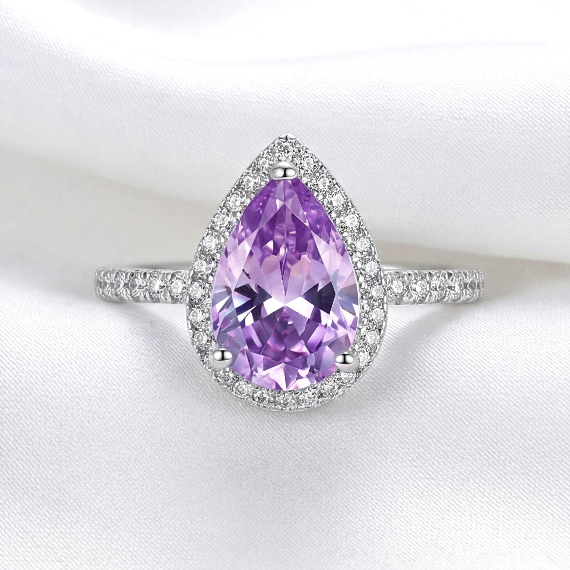 Front view of the teardrop simulated amethyst halo ring in S925 sterling silver on white silk.