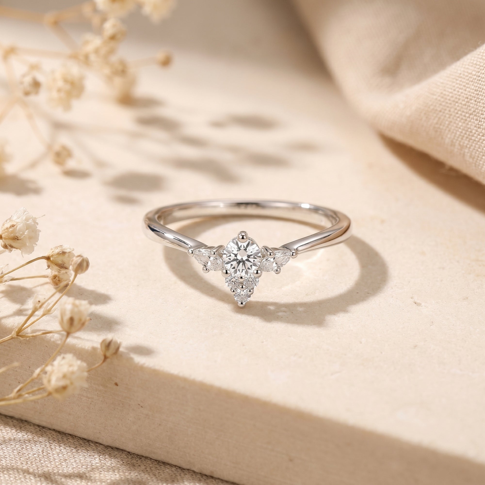Silver Lysianna ring with a round simulated diamond floral cluster on a neutral lifestyle background.