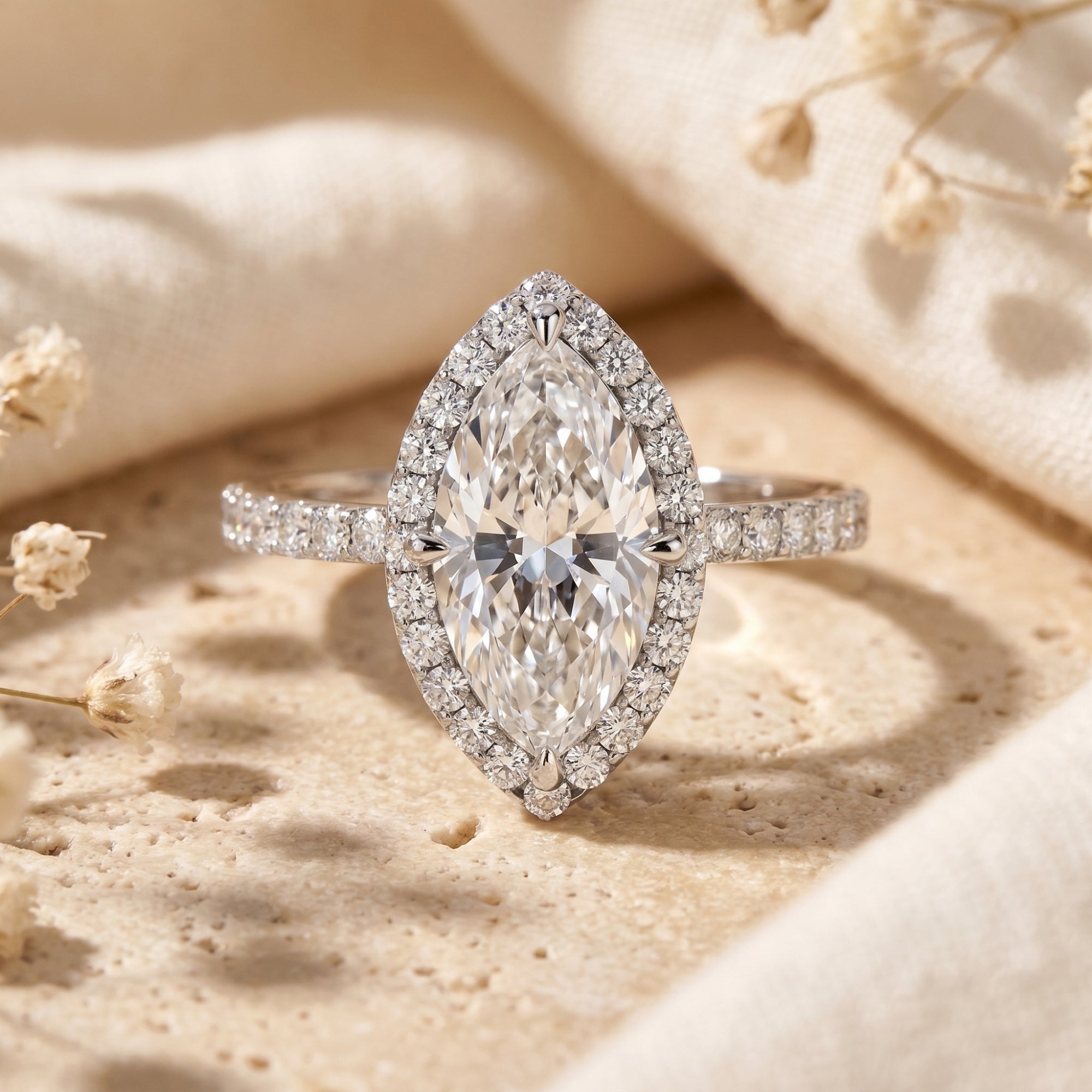 Marquise cut moissanite halo ring in sterling silver on a neutral lifestyle background.