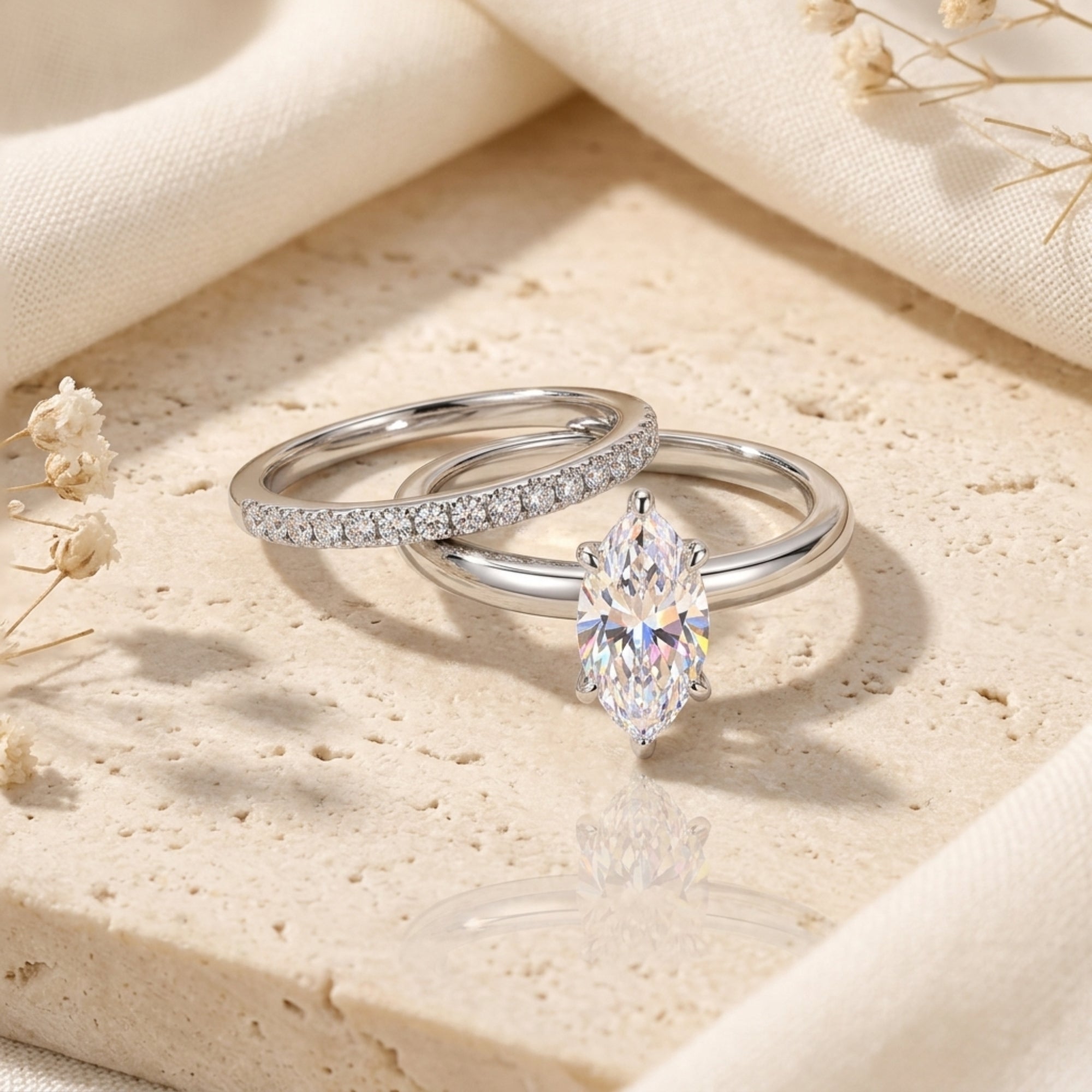 Marquise cut simulated diamond ring set in S925 sterling silver on a stone surface with dried flowers.