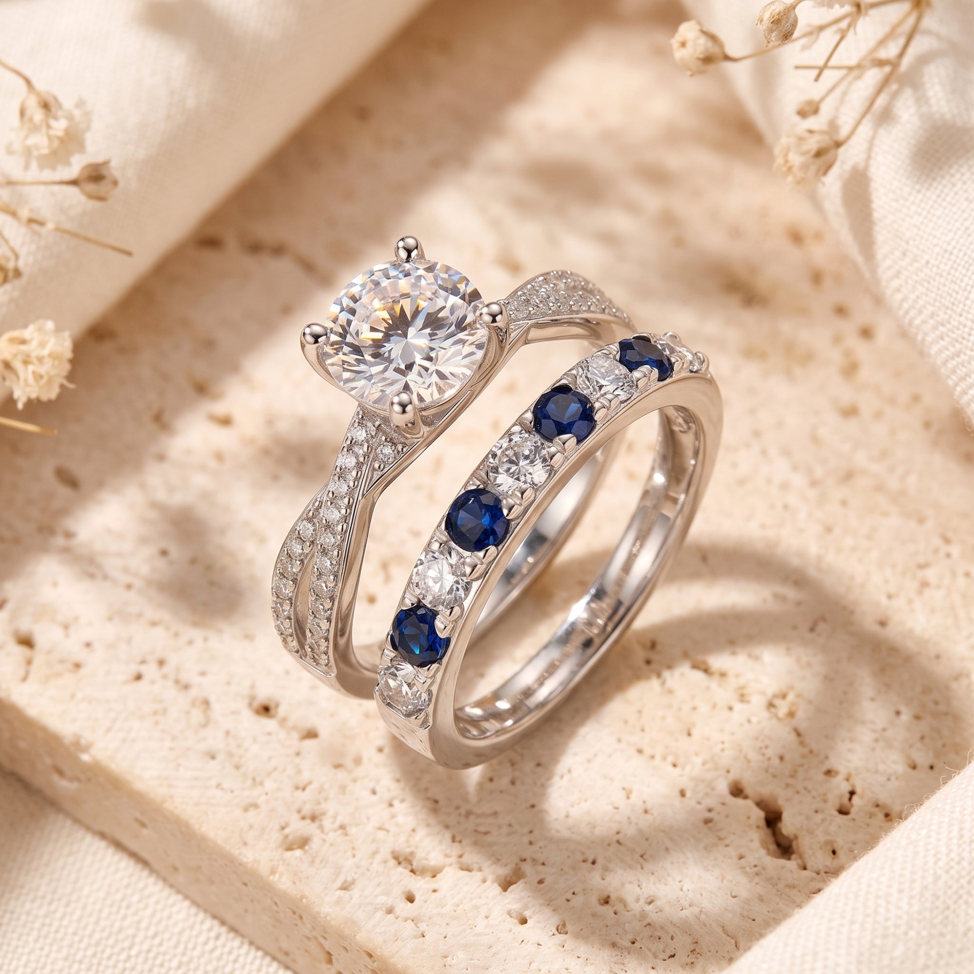 Fiona silver promise ring set with round-cut CZ and blue stones on a textured stone surface.