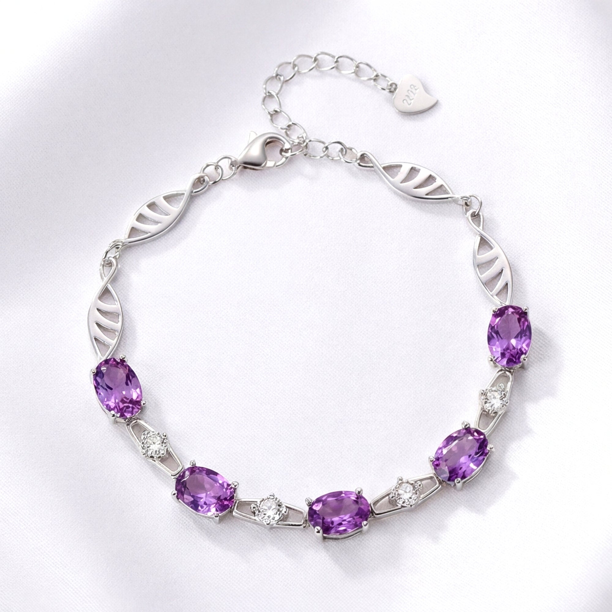 Lysandra link bracelet in S925 sterling silver with oval simulated amethyst stones on a white fabric background.