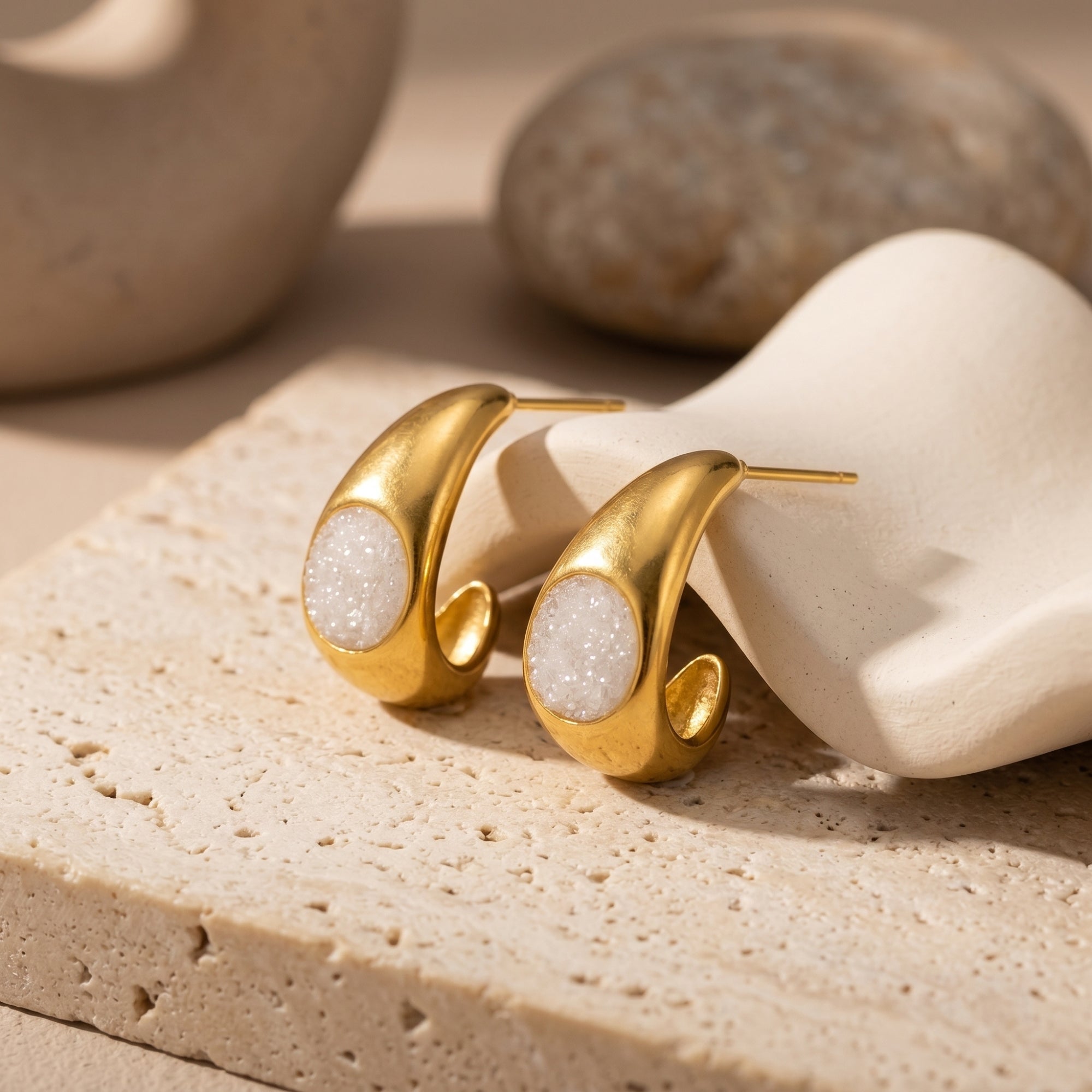 Gold PVD chunky huggie earrings with white quartz druzy on stone.