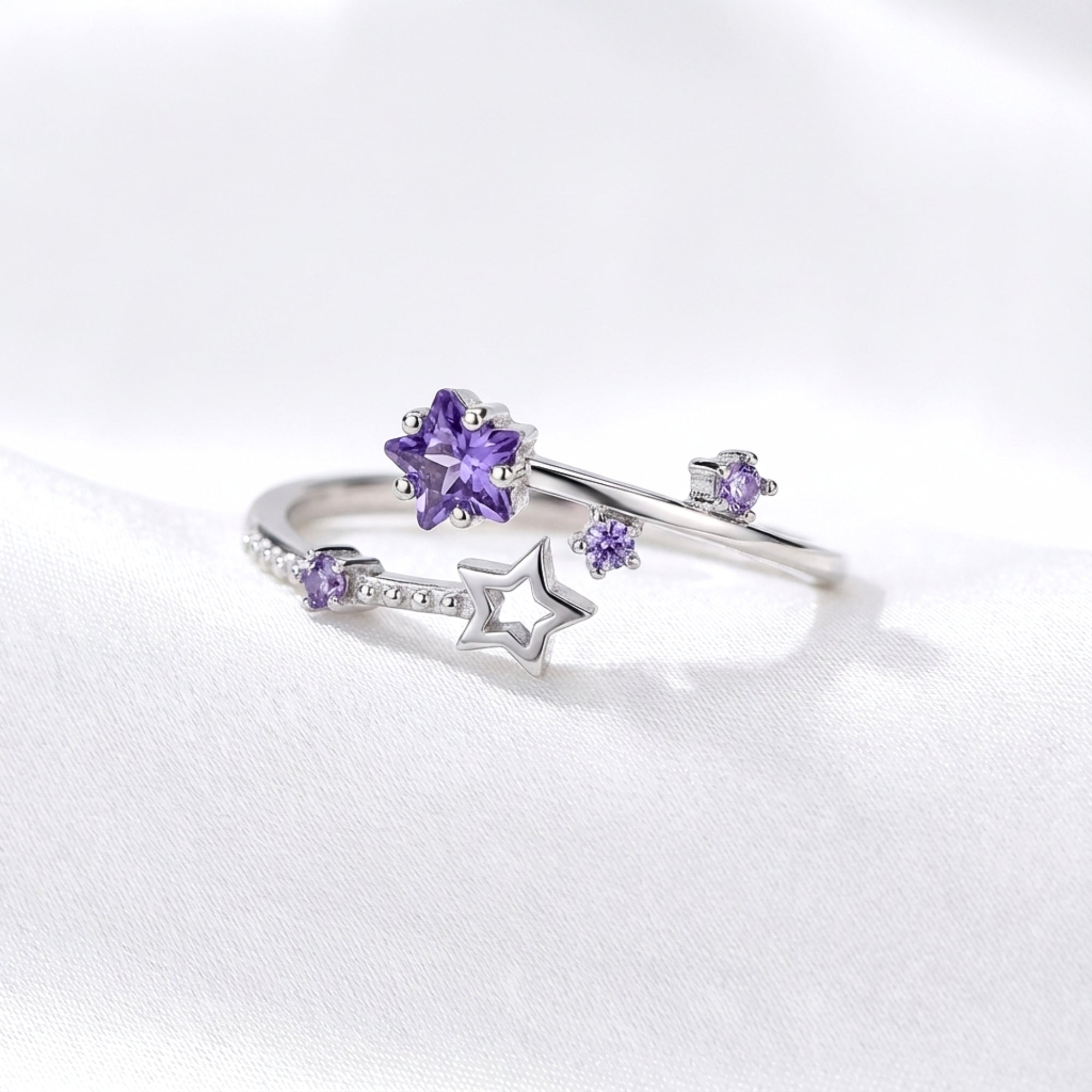 Side view of the S925 sterling silver Galaxia ring with star-cut purple simulated amethyst on white silk.