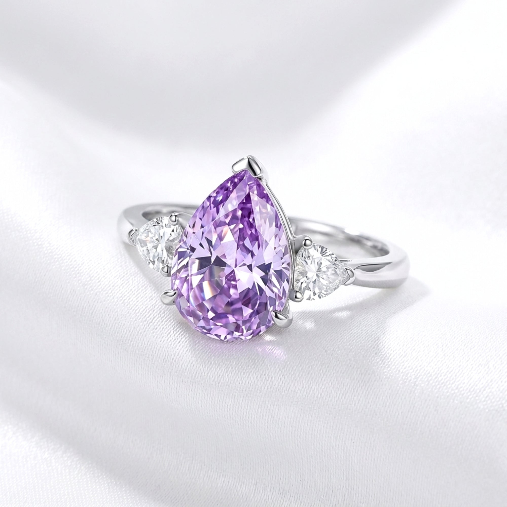 Pear-cut royal purple simulated amethyst ring in sterling silver on white silk, front view.