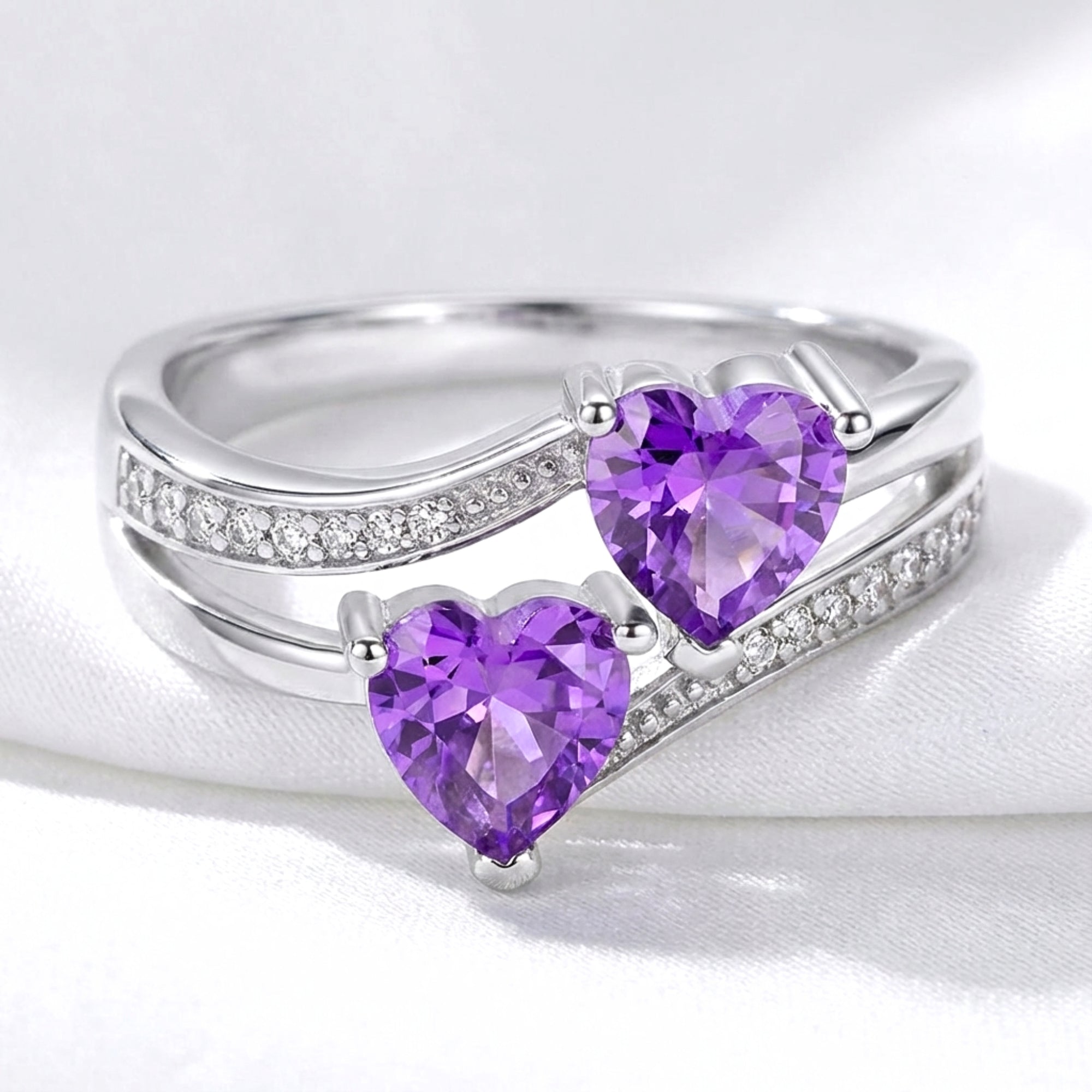 Front view of the Adara bypass heart ring in S925 sterling silver with two heart-cut purple simulated amethysts.