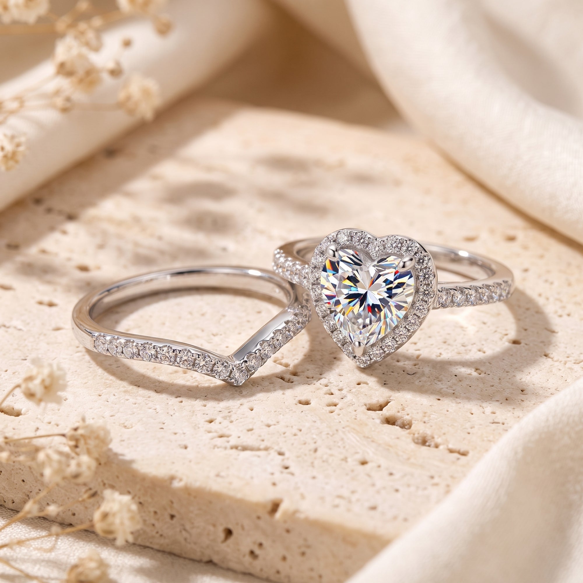 Silver heart halo ring and chevron band set on stone with floral accents.