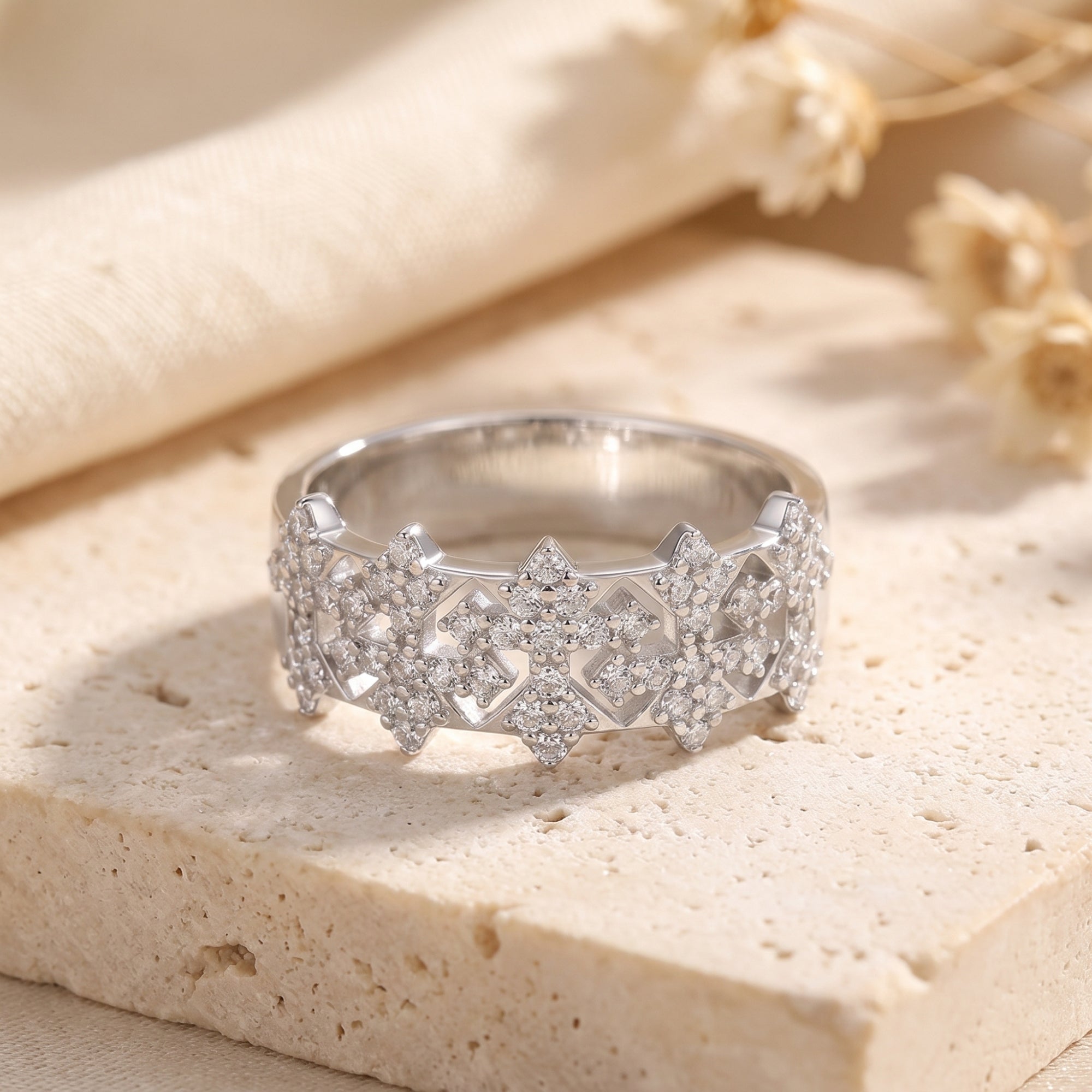 Sterling silver snowflake crown ring with simulated diamonds on a stone surface.