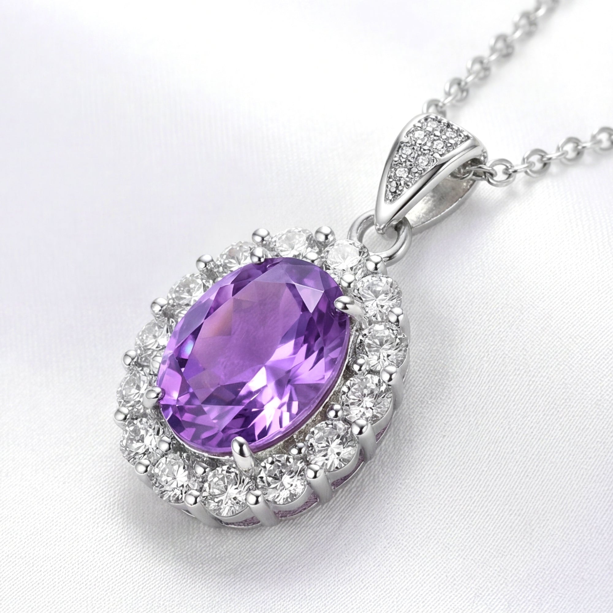 Oval cut simulated amethyst halo necklace in sterling silver on white silk.