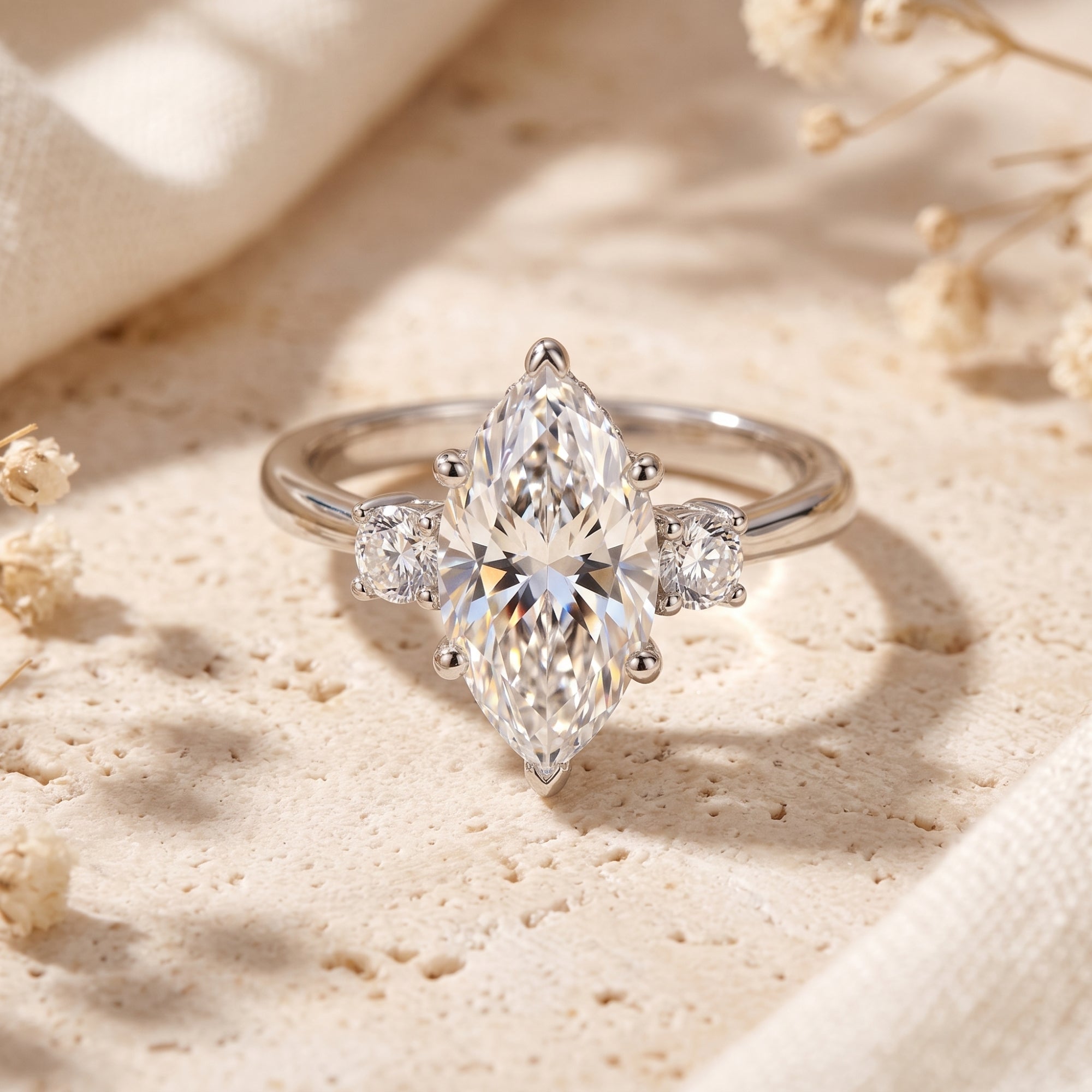 Marquise simulated diamond sterling silver ring on stone with flowers.