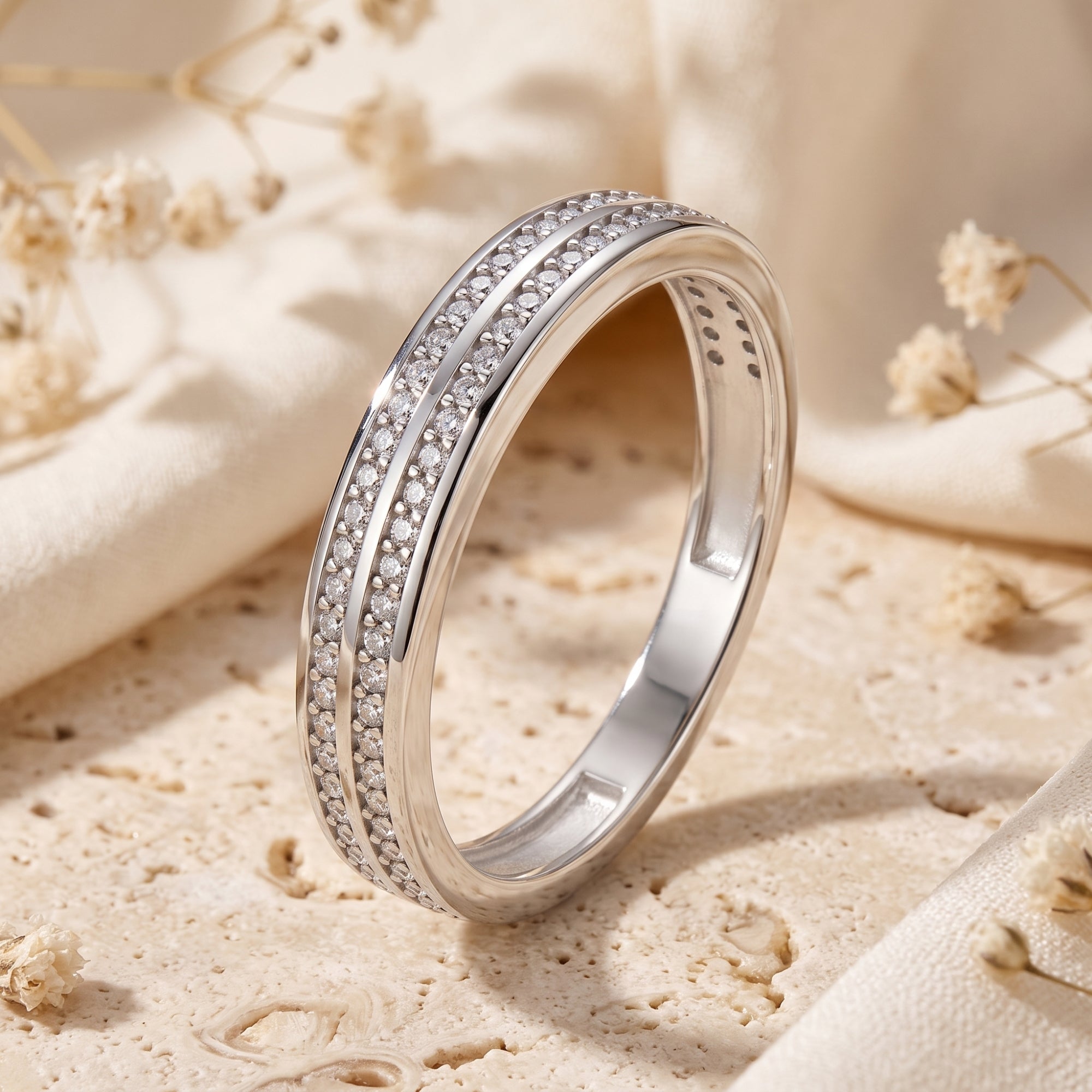 Angled view of the Margaux double-row pavé sterling silver ring with simulated diamonds on a stone surface.