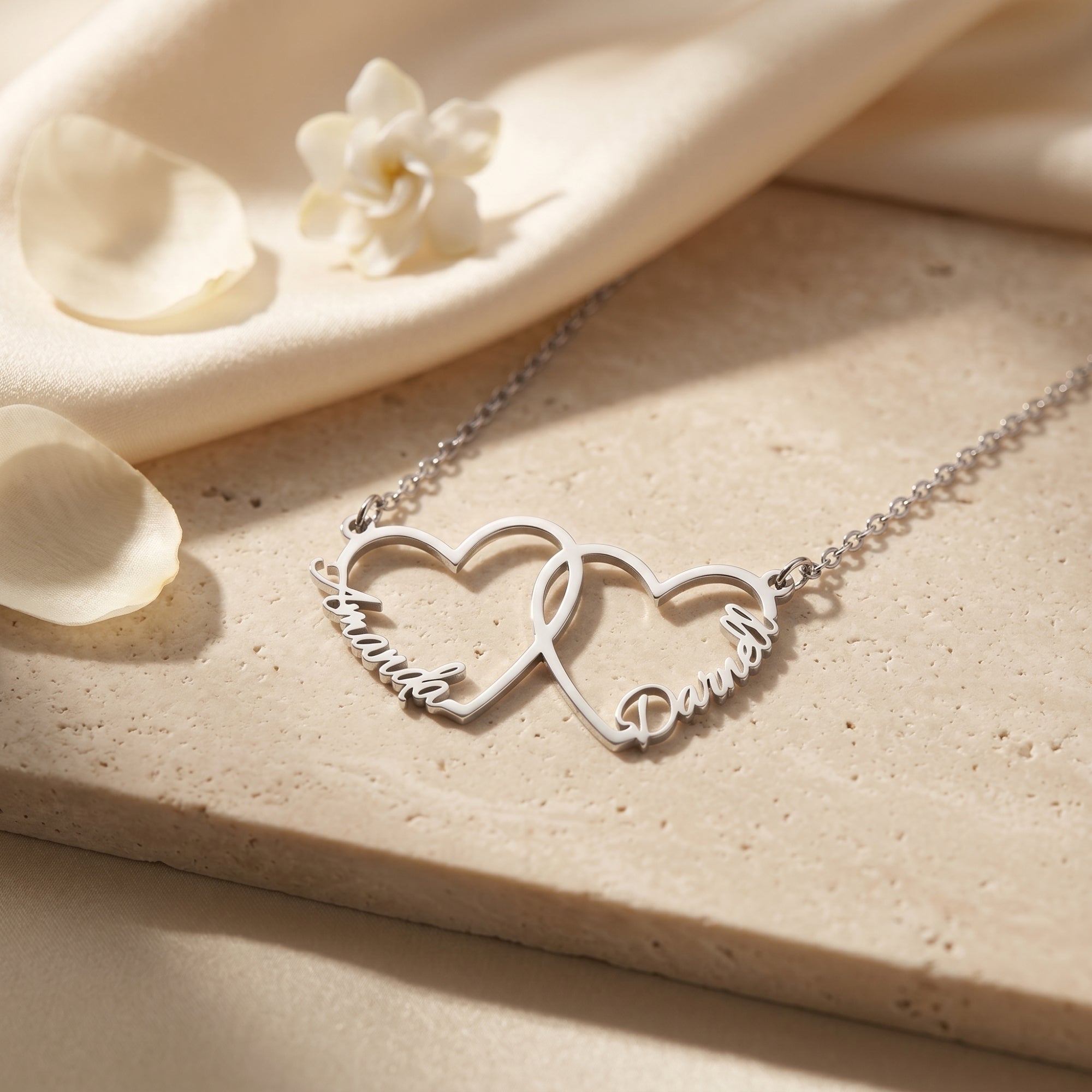 Silver stainless steel interlocking heart necklace with names on stone.