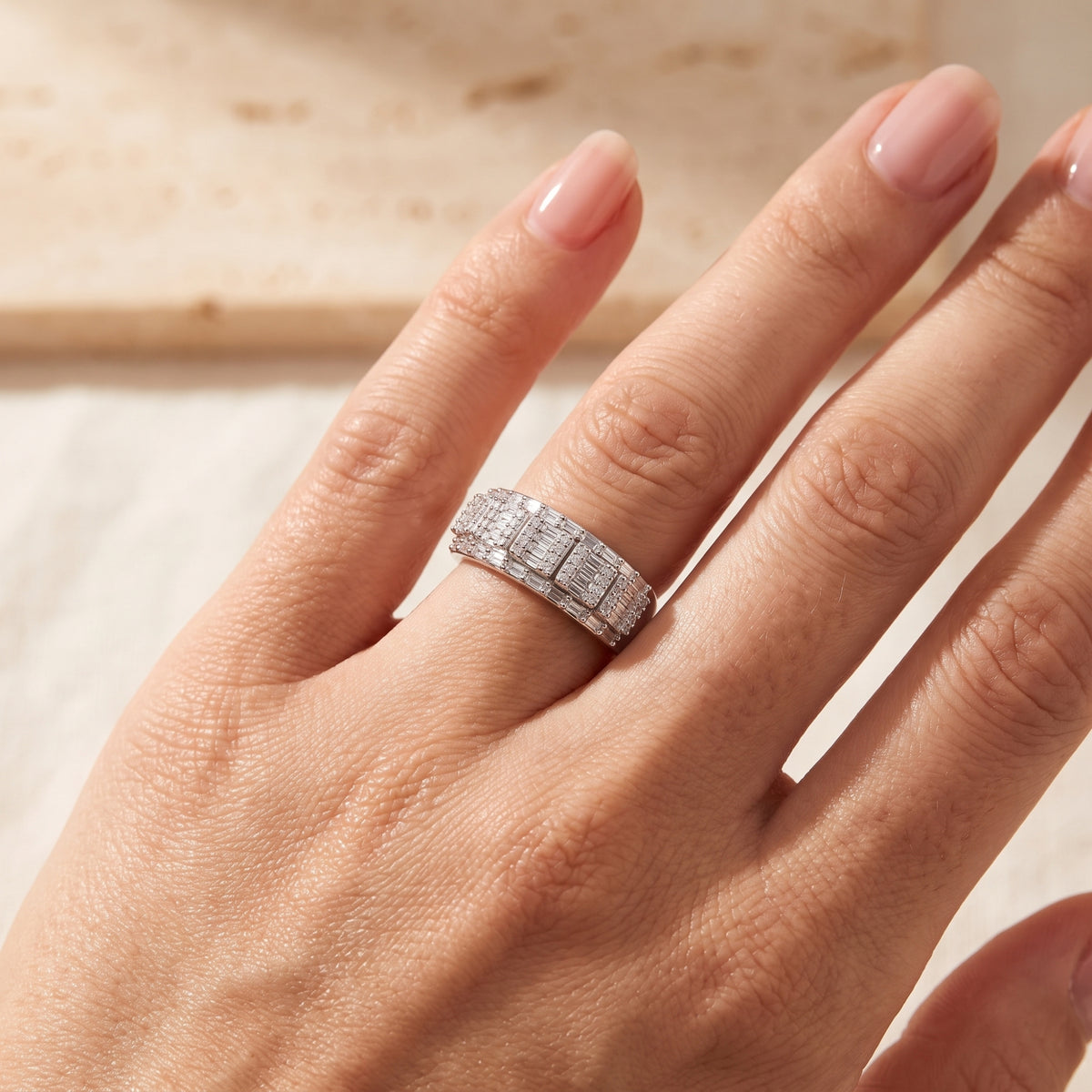 Top-down view of the silver mosaic column band ring worn on a finger.