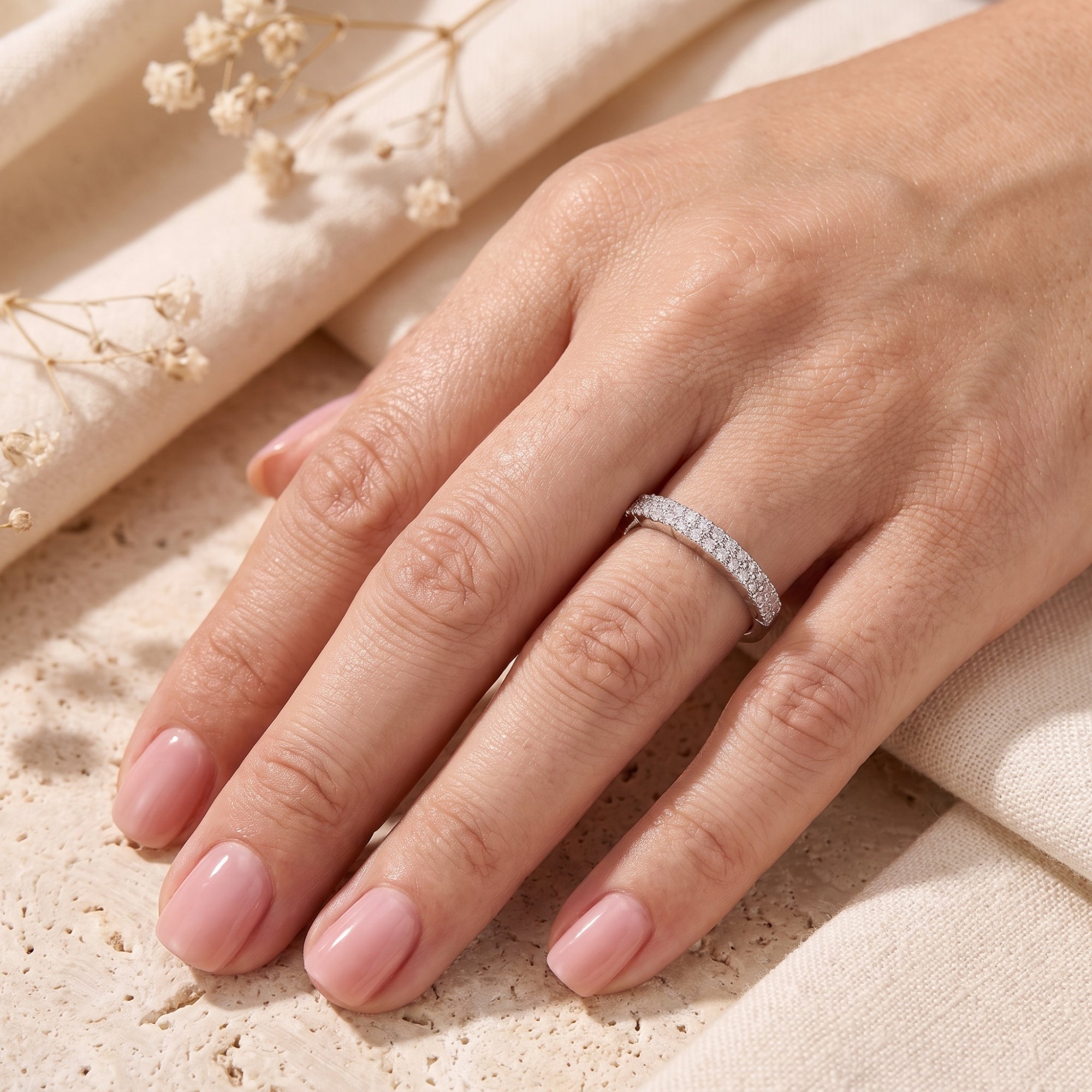 Sterling silver double row pavé promise ring with cubic zirconia worn on a hand.