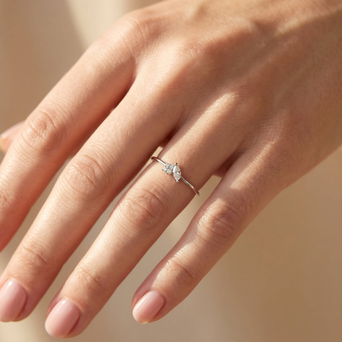Sterling silver marquise moissanite ring worn on a woman's hand.