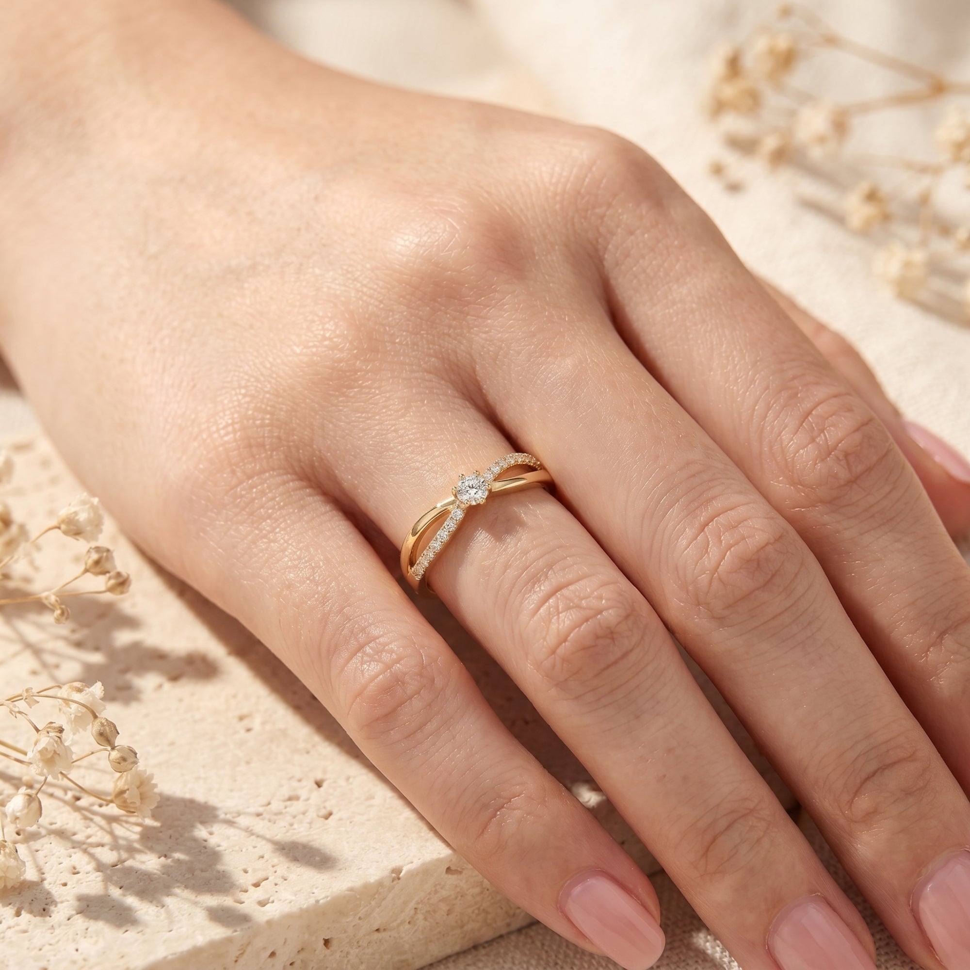 Gold bypass moissanite ring worn on a hand.