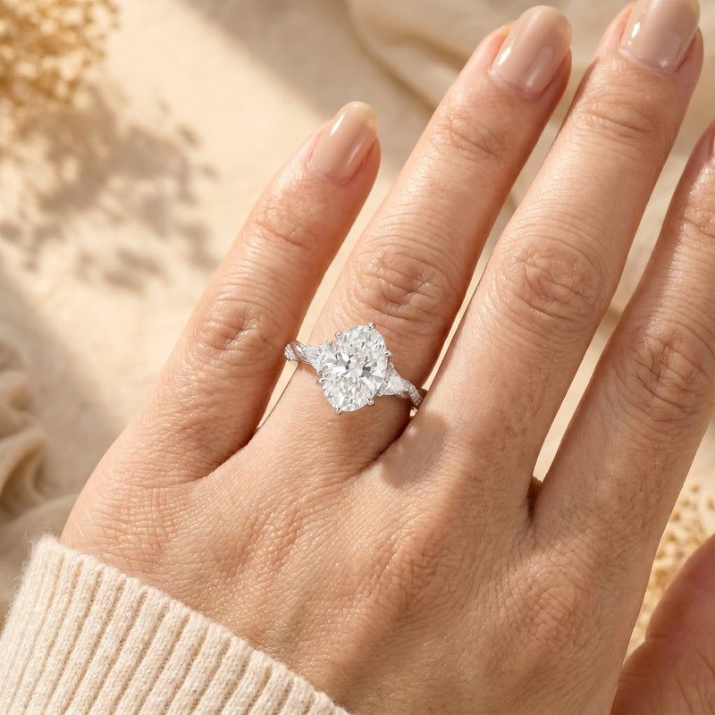 Oval cut moissanite ring in solid gold worn on a woman's finger to show 3-carat scale.