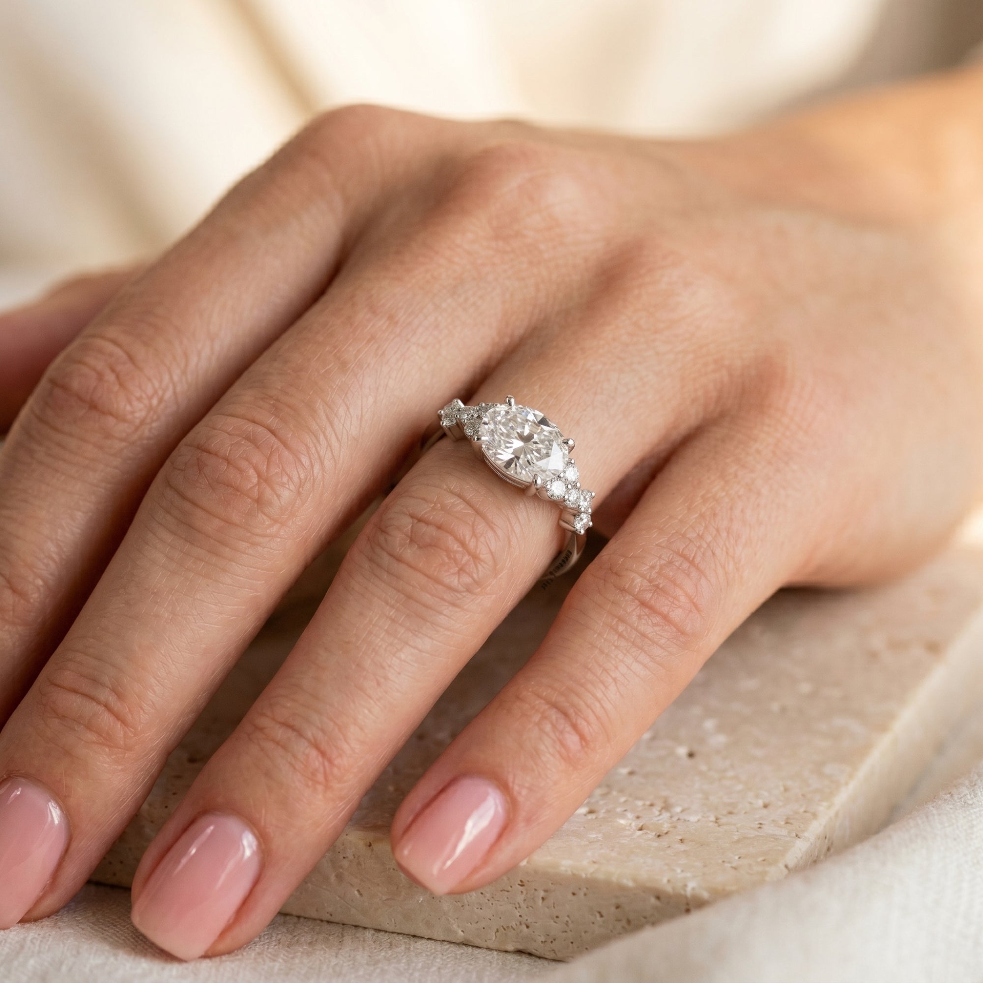 Woman wearing the silver Eulalique oval moissanite promise ring on her ring finger.