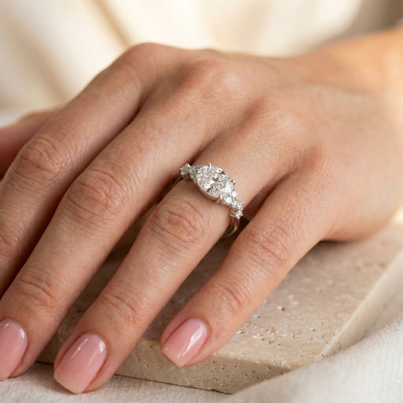 Woman wearing the silver Eulalique oval moissanite promise ring on her ring finger.