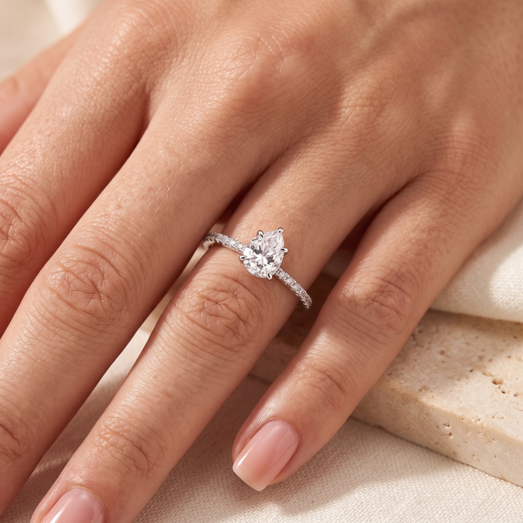 Teardrop simulated diamond ring in sterling silver worn on a woman's ring finger.