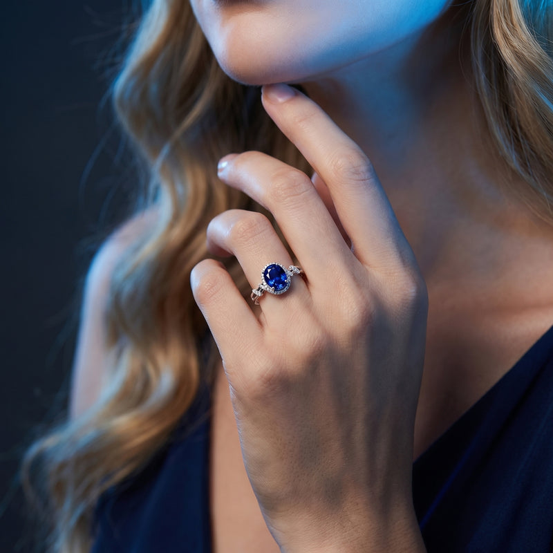 Model wearing the 18K white gold oval tanzanite and diamond halo ring on her finger.