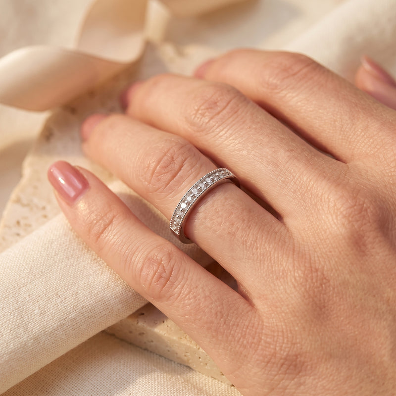 Hand wearing the silver milgrain band with clear stones, shown from a top-down perspective.