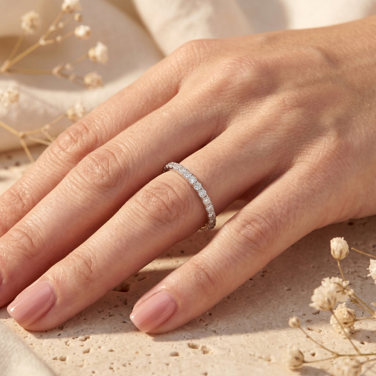 Woman wearing the Sylvienne moissanite pave band in sterling silver on her ring finger.