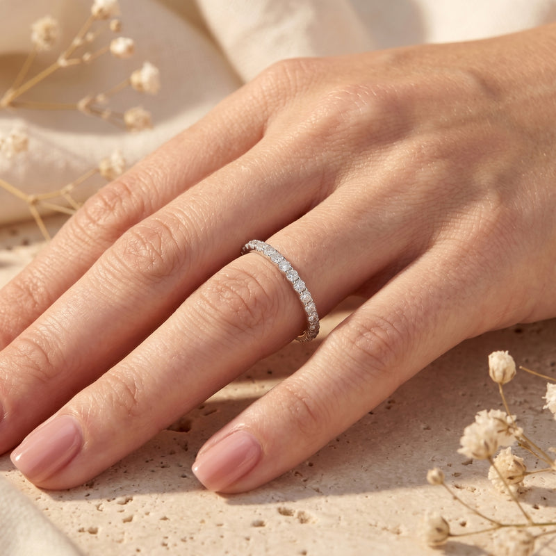 Woman wearing the Sylvienne moissanite pave band in sterling silver on her ring finger.