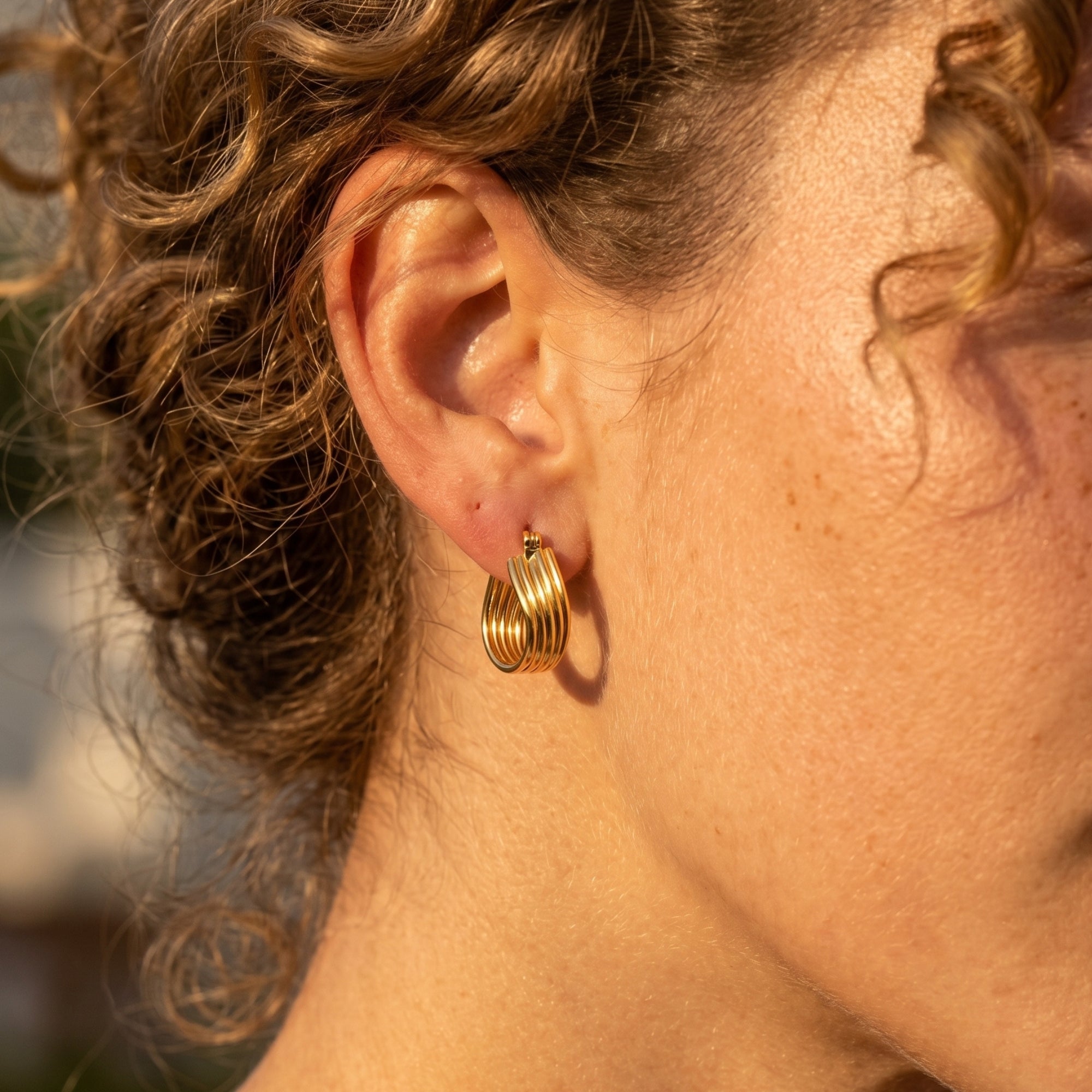 18K gold plated multi-row hoop earring shown on a model's ear.