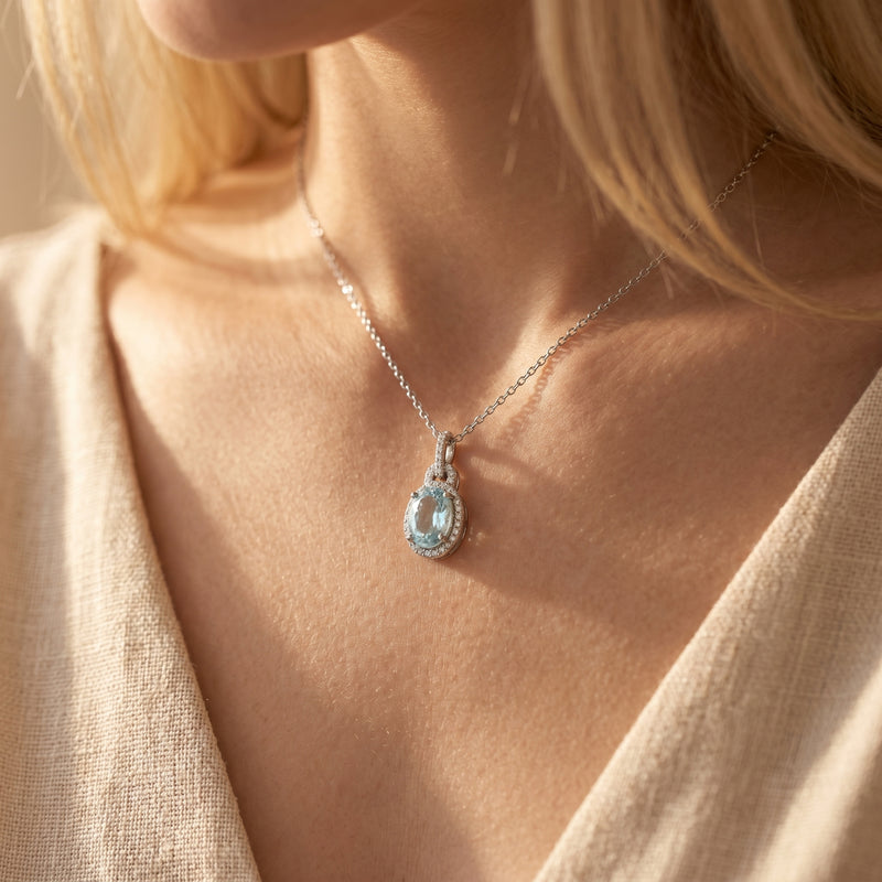 Model wearing the Bianca silver necklace with an oval-cut aquamarine pendant.