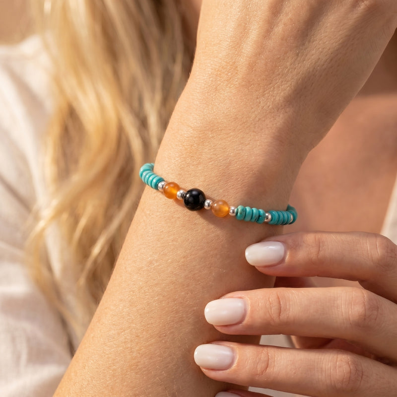 Turquoise and onyx bead bracelet in sterling silver worn on a woman's wrist for a Southwestern look.