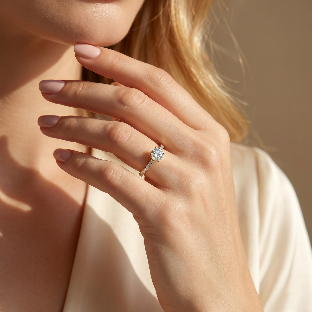 A stunning gold round-cut moissanite engagement ring being worn on a woman's hand, showcasing its sparkle.