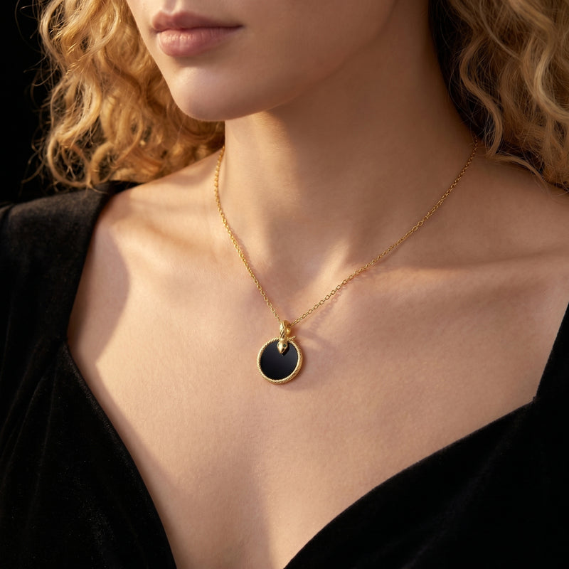 Model wearing the gold Polaris snake necklace with a round black onyx pendant.